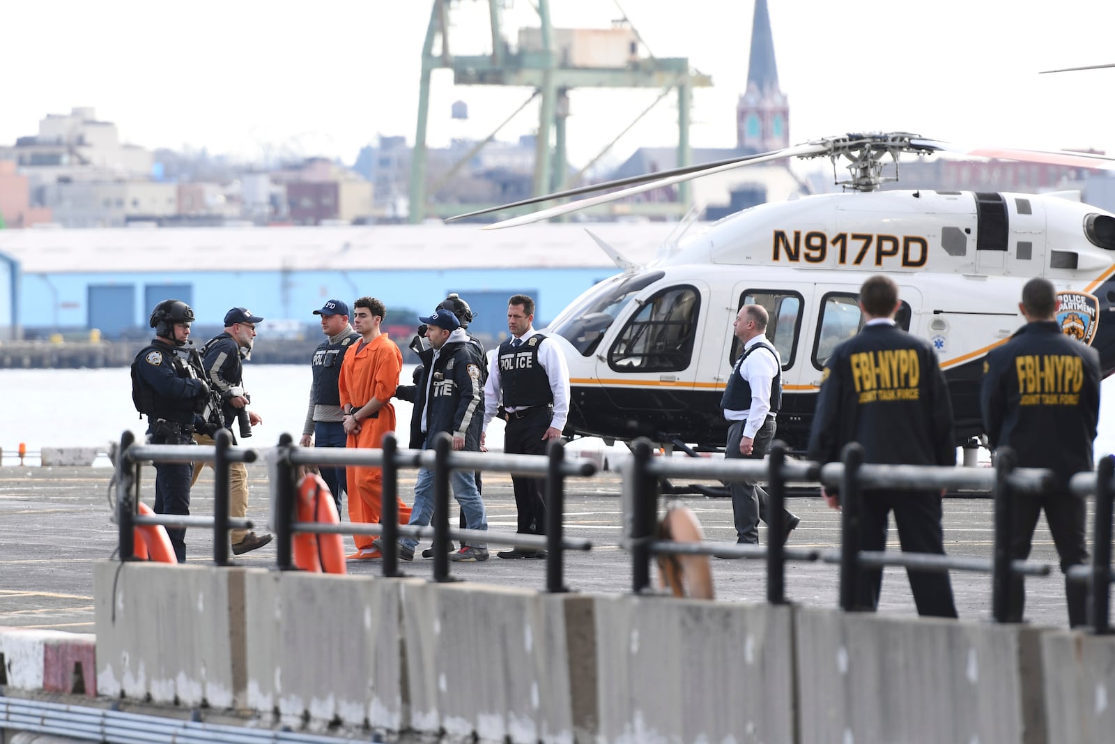 Luigi Mangione, a suspect in the fatal shooting of UnitedHealthcare CEO Brian Thompson, is escorted off of a helicopter by police, Thursday, Dec. 19, 2024, in New York. (AP Photo/Pamela Smith)