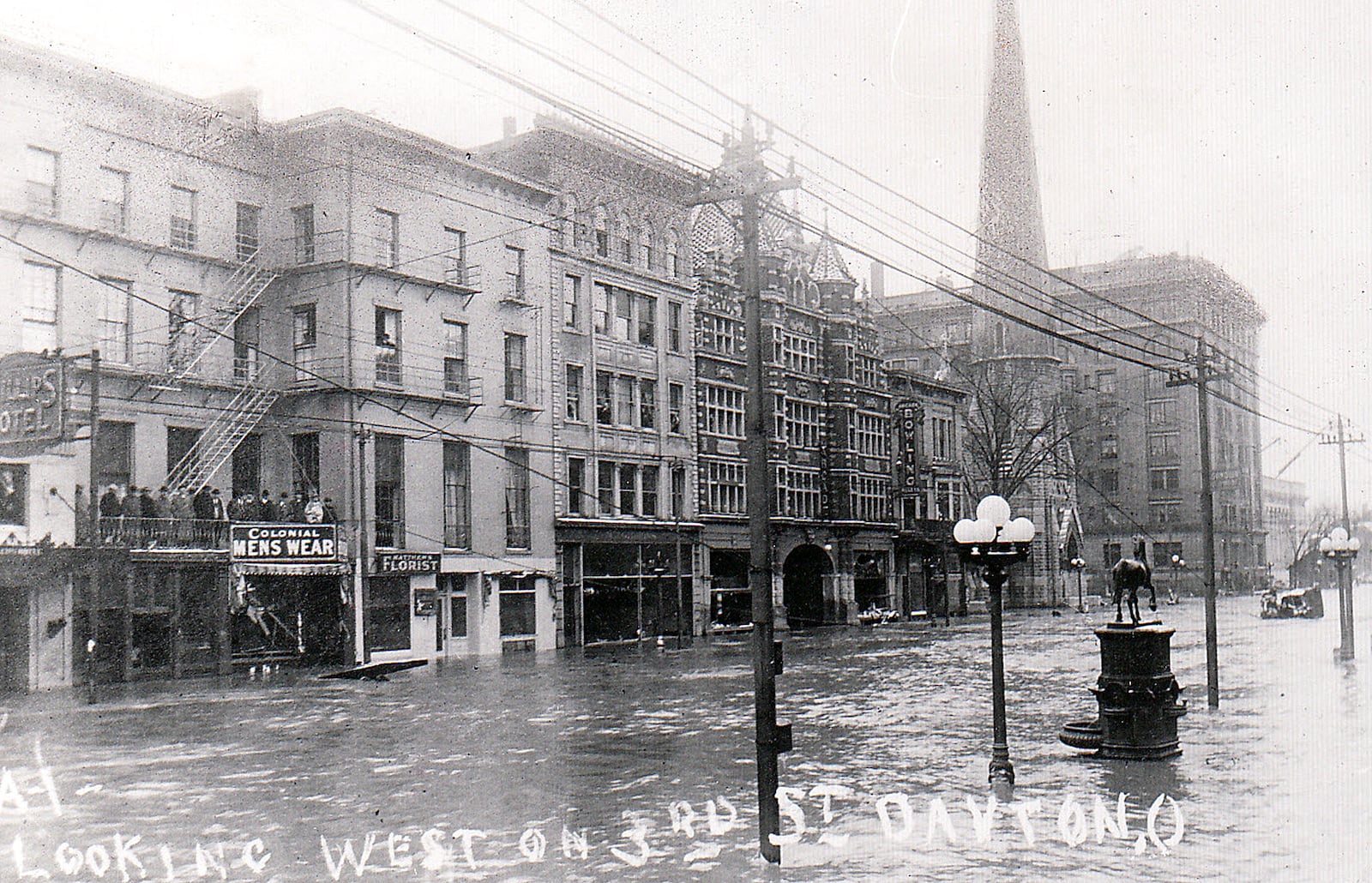  Third Street in downtown Dayton during the Great Dayton Flood of 1913. At the time the street featured a hotel, a menswear store, a florist and the Arcade building (just before the "bowling" sign in the photo) among other buildings.