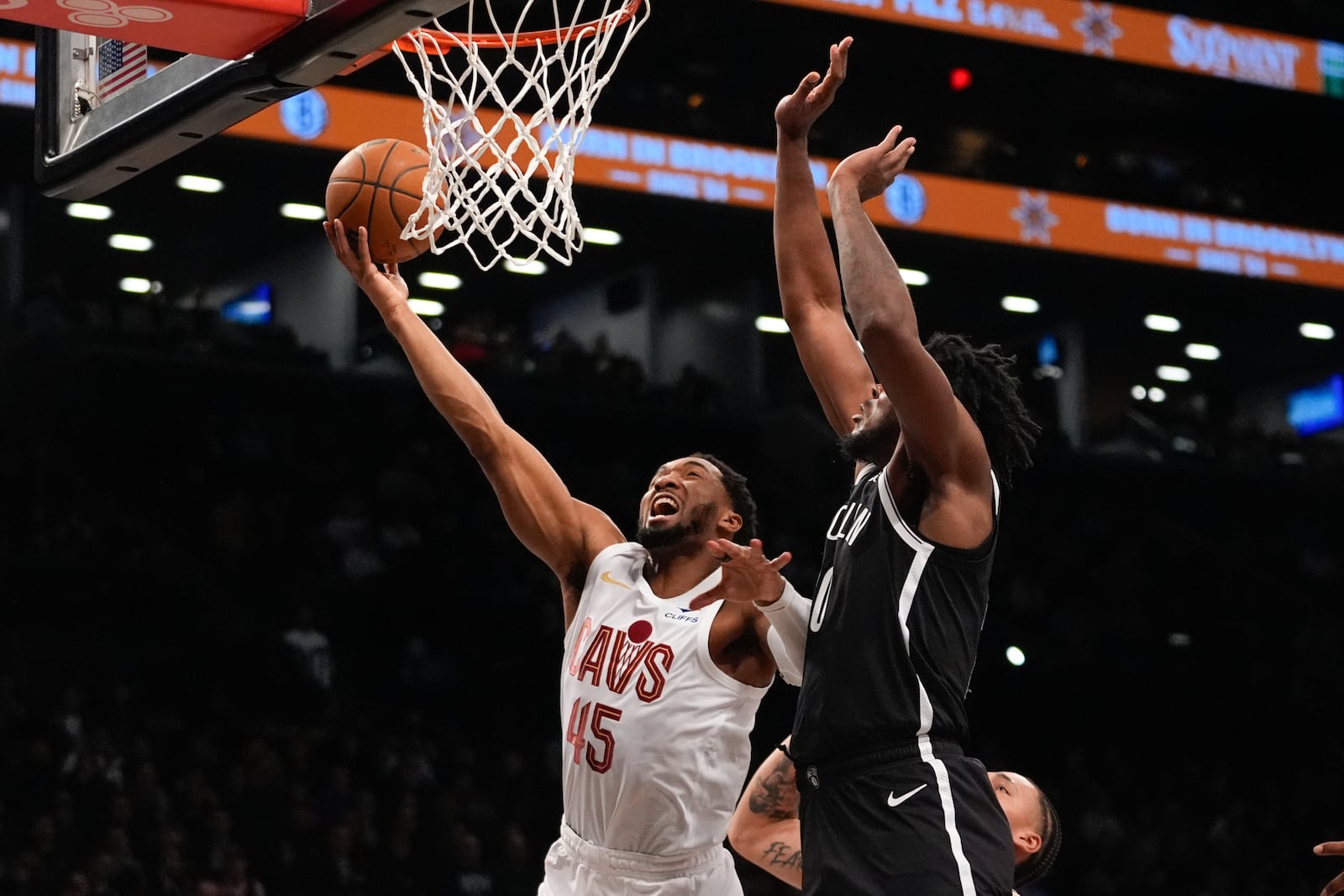 Cleveland Cavaliers' Donovan Mitchell (45) drives past Brooklyn Nets' Day'Ron Sharpe (20) during the first half of an NBA basketball game Thursday, Feb. 20, 2025, in New York. (AP Photo/Frank Franklin II)