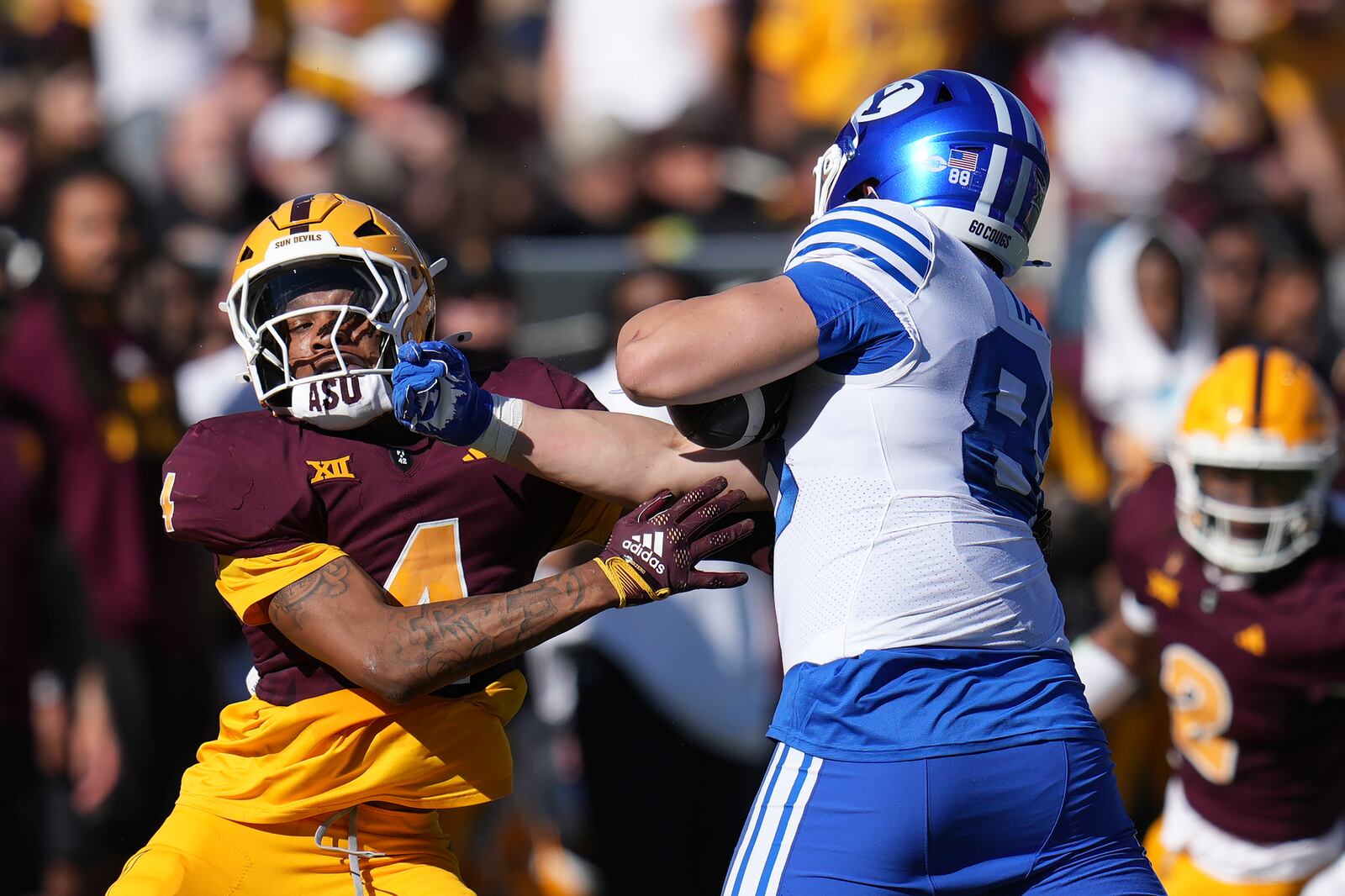 BYU tight end Mata'ava Ta'ase, right, tries to get past Arizona State defensive back Myles Rowser, left, during the first half of an NCAA college football game Saturday, Nov. 23, 2024, in Tempe, Ariz. (AP Photo/Ross D. Franklin)