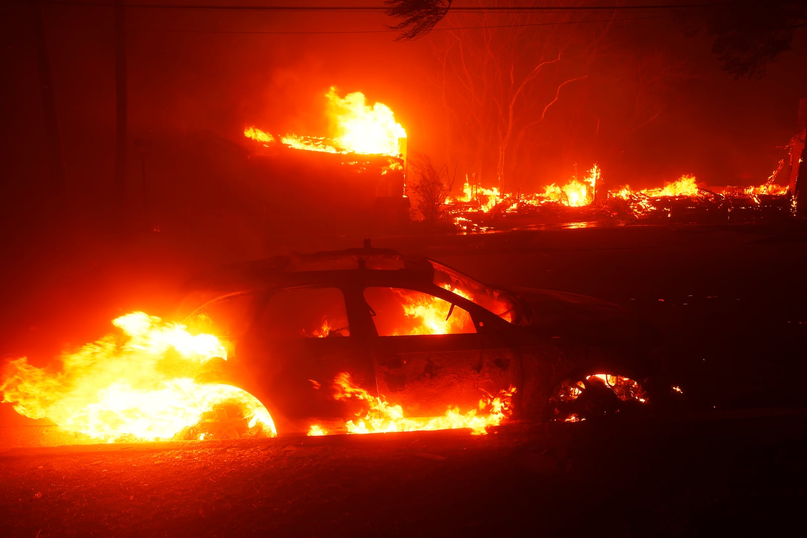 A vehicle burns as the Palisades Fire sweeps through in the Pacific Palisades neighborhood of Los Angeles, Tuesday, Jan. 7, 2025. (AP Photo/Etienne Laurent)