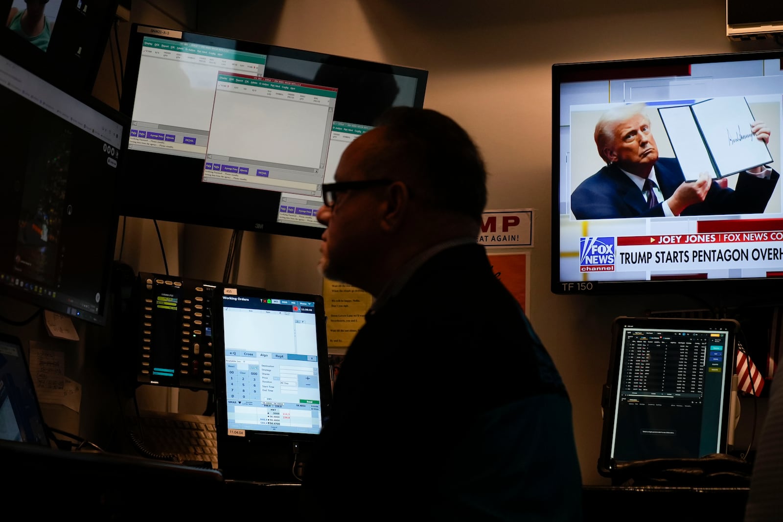 President Donald Trump appears on a screen as traders work on the floor at the New York Stock Exchange in New York, Tuesday, Jan. 21, 2025. (AP Photo/Seth Wenig)