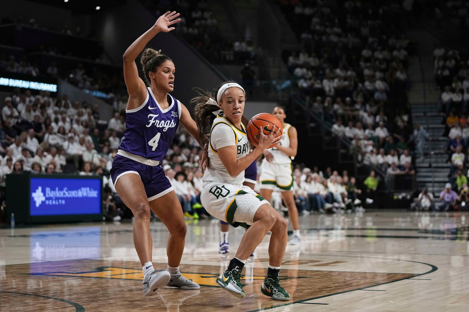 Baylor guard Jada Walker, right, works to the basket against TCU guard Donovyn Hunter (4) in the first half of an NCAA college basketball game in Waco, Texas, Sunday, March 2, 2025. (AP Photo/Tony Gutierrez)