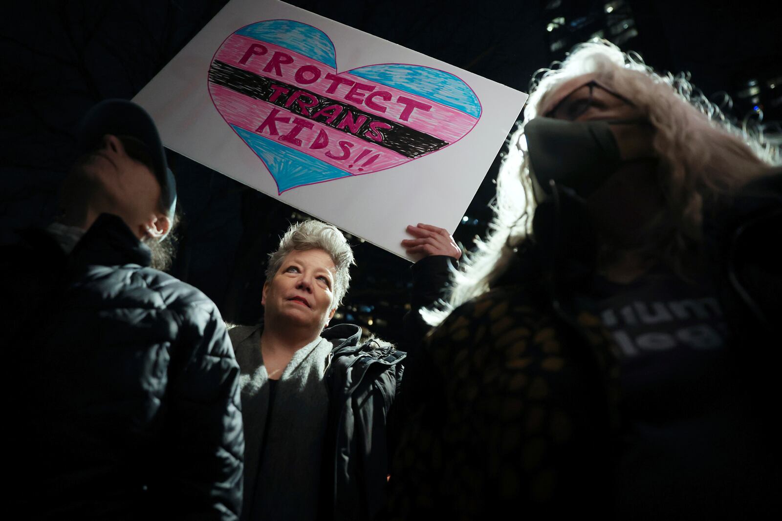 Ann B. Brown, center, holds up a sign during a rally demanding that NYU Langone commit to providing gender-affirming care for transgender youth following an executive order by President Donald Trump aimed at cutting federal funding, Monday, Feb. 3, 2025, in New York. (AP Photo/Heather Khalifa)