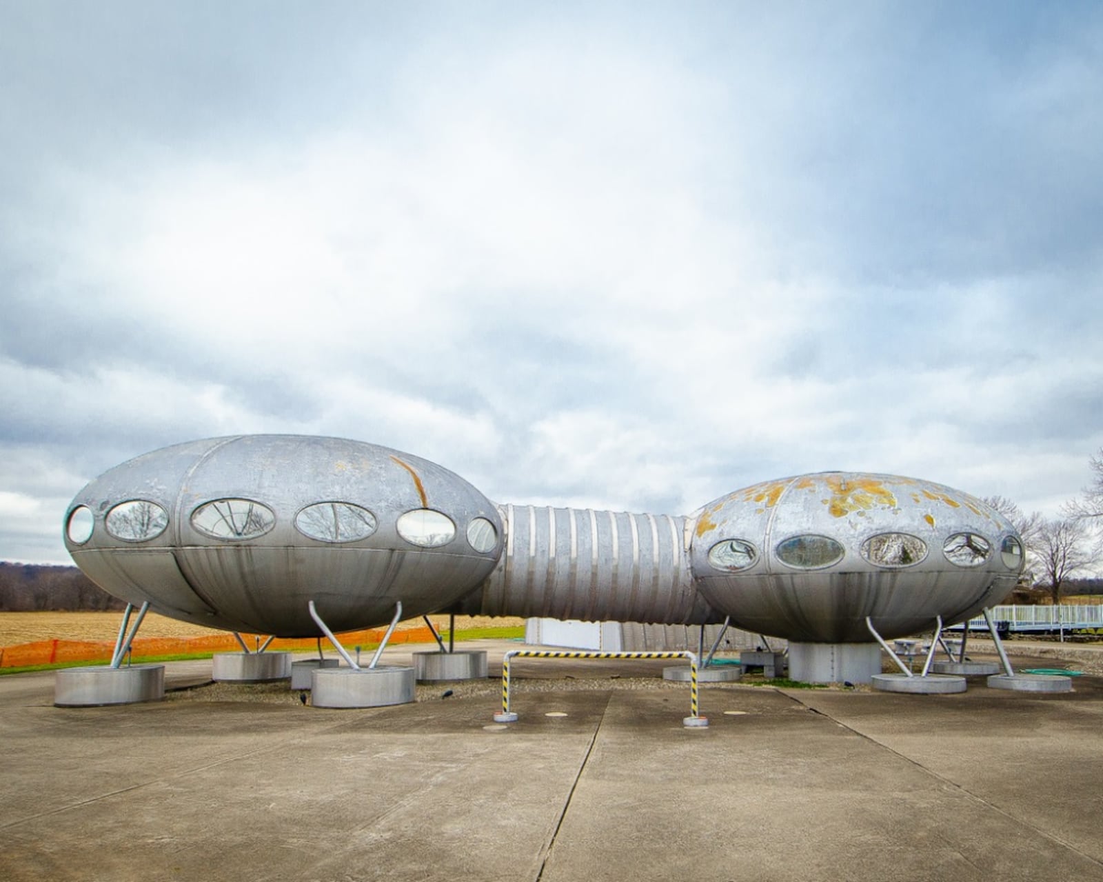 Two oblong silver looking flying saucers joined by a walkway are actually a portable, prefabricated home design from 1968 is by Finnish architect Matti Suuronen. It's located in Carlisle.