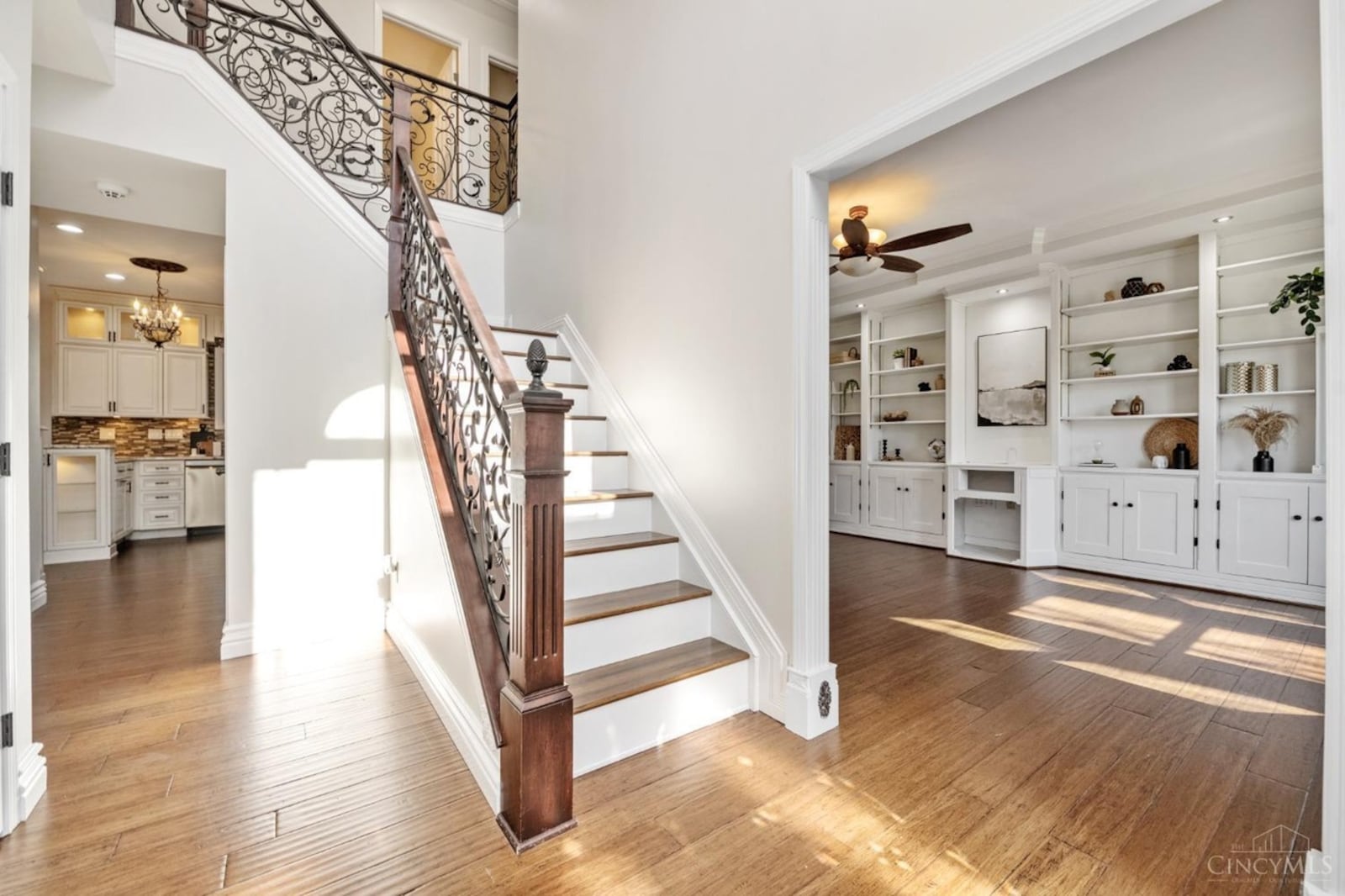 The wood staircase off the entry has decorative wrought iron railings.