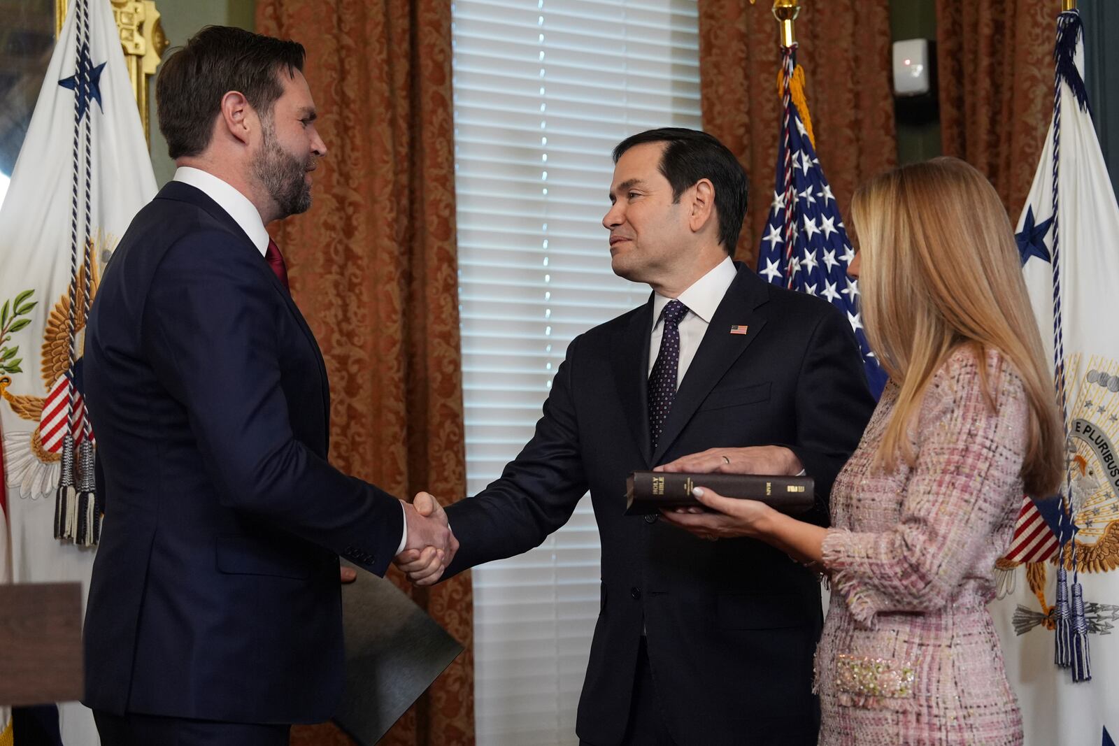 Secretary of State Marco Rubio shakes hands with Vice President JD Vance, after being sworn in, in the Vice Presidential Ceremonial Office in the Eisenhower Executive Office Building on the White House campus, Tuesday, Jan. 21, 2025, in Washington, as his wife, Jeanette Rubio, looks on. (AP Photo/Evan Vucci)