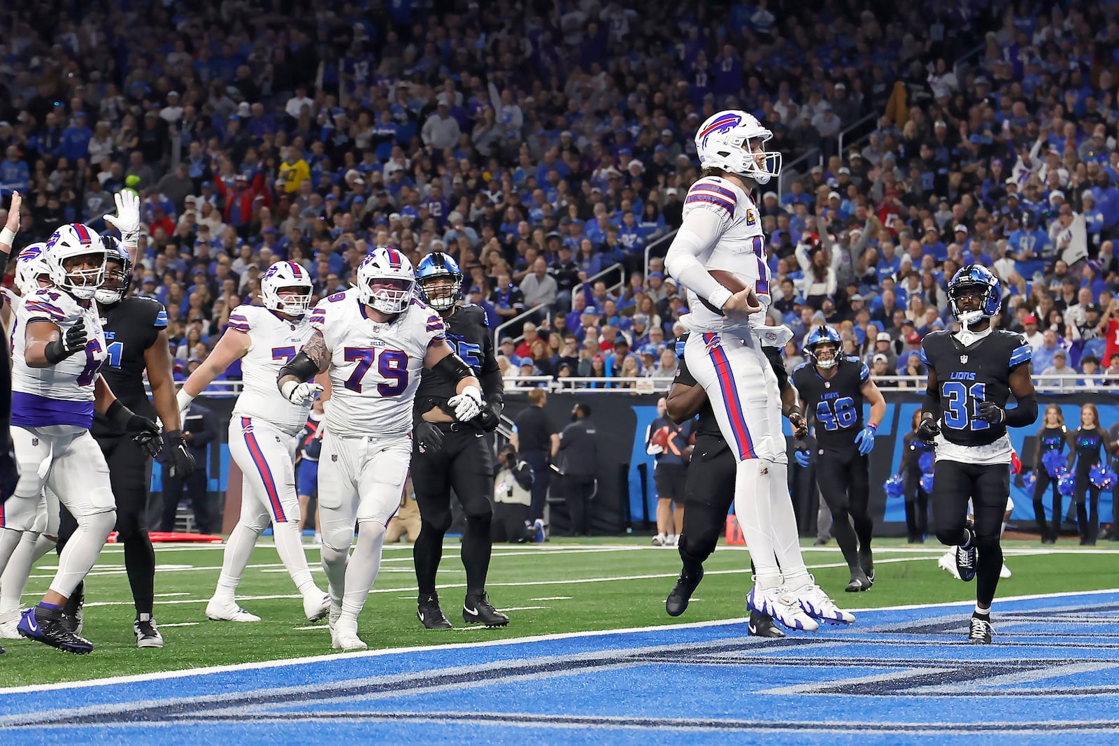 Buffalo Bills quarterback Josh Allen, foreground, celebrates after scoring against the Detroit Lions during the first half of an NFL football game, Sunday, Dec. 15, 2024, in Detroit. (AP Photo/Rey Del Rio)