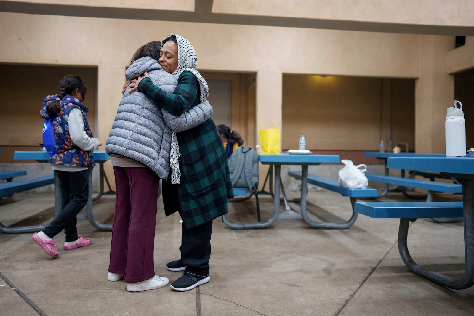 Farzana Asaduzzaman, left, hugs Sakeenah Ali during a community gathering to discuss plans for Ramadan for members of the Masjid Al-Taqwa, held at a school in Pasadena, California, Saturday, Feb. 15, 2025. (AP Photo/Eric Thayer)