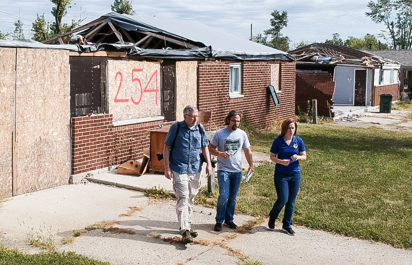 Dayton Daily News reporters Chris Stewart, left, and Josh Sweigart are retracing the path of a devastating EF4 Memorial Day tornado that cut across Montgomery County. They are seen with WHIO Chief Meteorologist McCall Vrydaghs on one leg of the journey through Brookville. CHUCK HAMLIN / STAFF