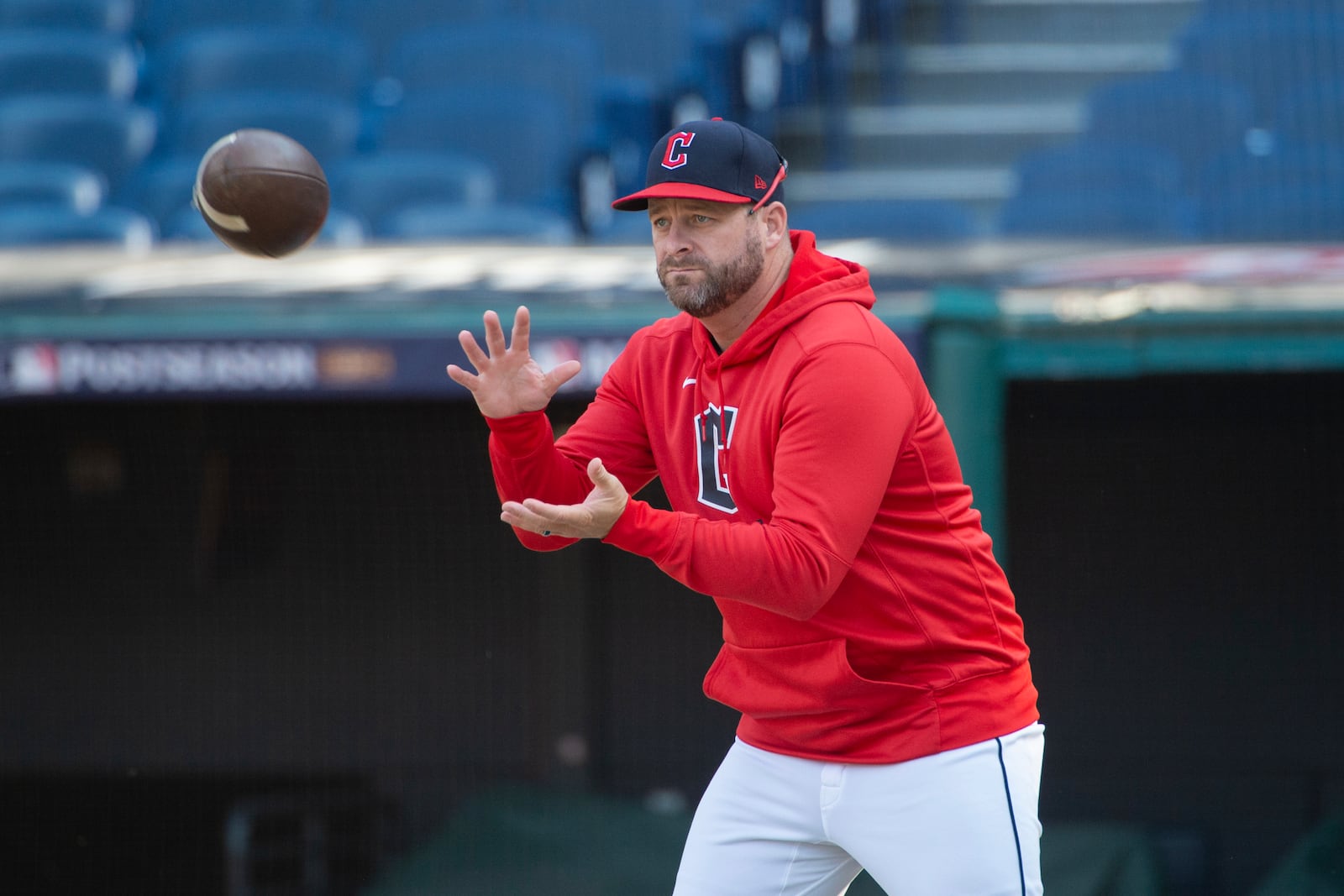 Cleveland Guardians manager Stephen Vogt catches a football during a baseball workout in Cleveland, Friday, Oct. 11, 2024, in preparation for Saturday's Game 5 of the American League Division Series against the Detroit Tigers.(AP Photo/Phil Long)