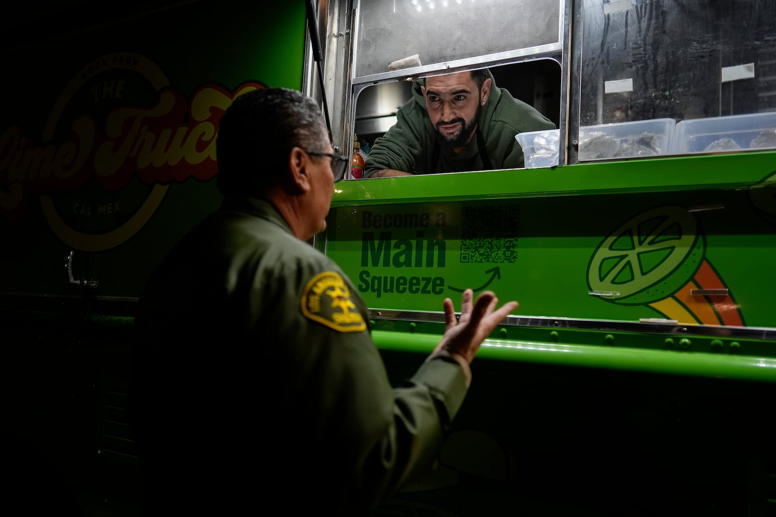 World Central Kitchen Chef Corp member Daniel Shemtob talks with an Eaton Fire first responder as he serves burritos from his food truck, The Lime Truck, at the Rose Bowl Stadium, Wednesday, Jan. 15, 2025, in Pasadena, Calif. (AP Photo/Carolyn Kaster)