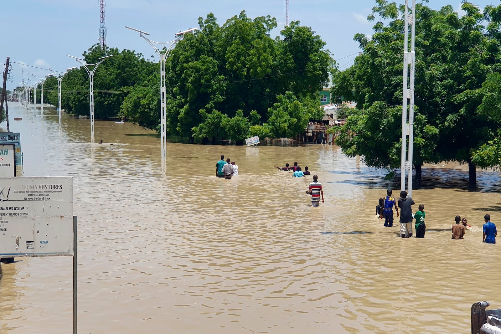 FILE - People walk through floodwaters following a dam collapse in Maiduguri, Nigeria Sept 10, 2024. (AP Photos/ Joshua Olatunji, File)