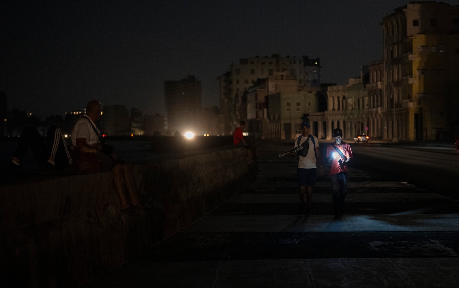 Residents walk on a street during a general blackout in Havana, Cuba, Friday, March 14, 2025. (AP Photo/Ramon Espinosa)