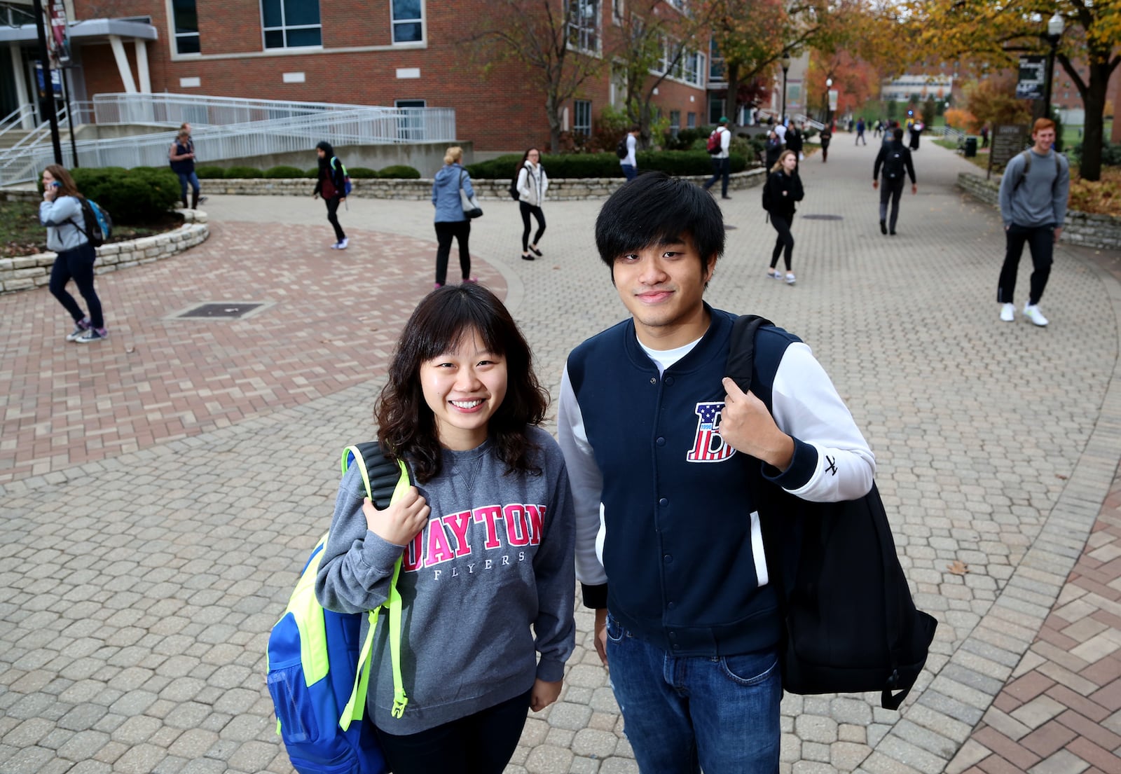 Xueyin Shi (left) and Yiqing Zhou, graduate students at the University of Dayton, started broadcasting the UD basketball games in Mandarian back home to China in 2015. LISA POWELL / STAFF