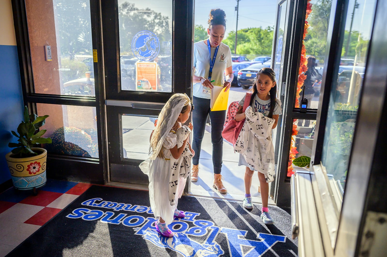 Attendance Clerk Katrice Grant follows siblings Melanie Pacheco, 8, right and Marilynn Pacheco, 5, as they arrive for school, Tuesday, Oct. 1, 2024, at Algodones Elementary School in Algodones, N.M. (AP Photo/Roberto E. Rosales)