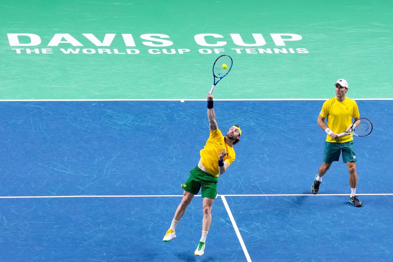 Australia's Jordan Thompson, left, returns the ball, next to Matthew Ebden against Tommy Paul and Ben Shelton of the United States during their doubles tennis quarterfinal Davis Cup match at the Martin Carpena Sports Hall, in Malaga, southern Spain, on Thursday, Nov. 21, 2024. (AP Photo/Manu Fernandez)