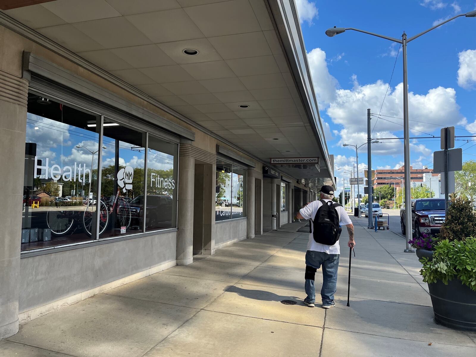 A man walks by a row of storefront businesses located along the 100 block of West Third Street. CORNELIUS FROLIK / STAFF