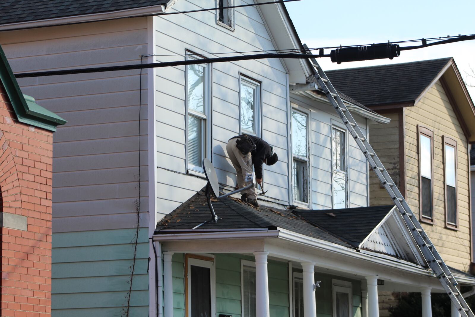 A construction worker on the roof of a home in the South Park neighborhood on Wednesday. Dayton plans to spend millions of dollars of federal rescue funds on housing and home repairs. CORNELIUS FROLIK / STAFF