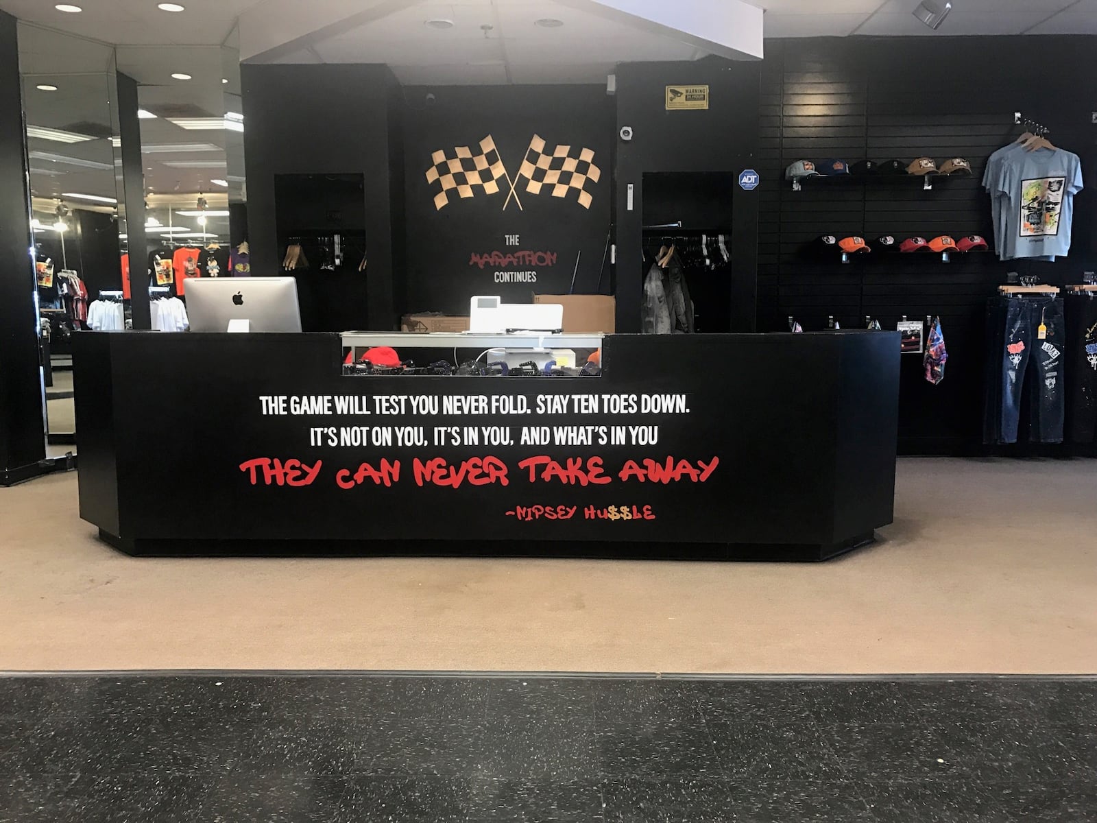 One of the inspirational sayings of Nipsey Hussle is highlighted on the on the counter of the stylish 48th Clothing store in the Northwest Plaza. Tom Archdeacon/STAFF