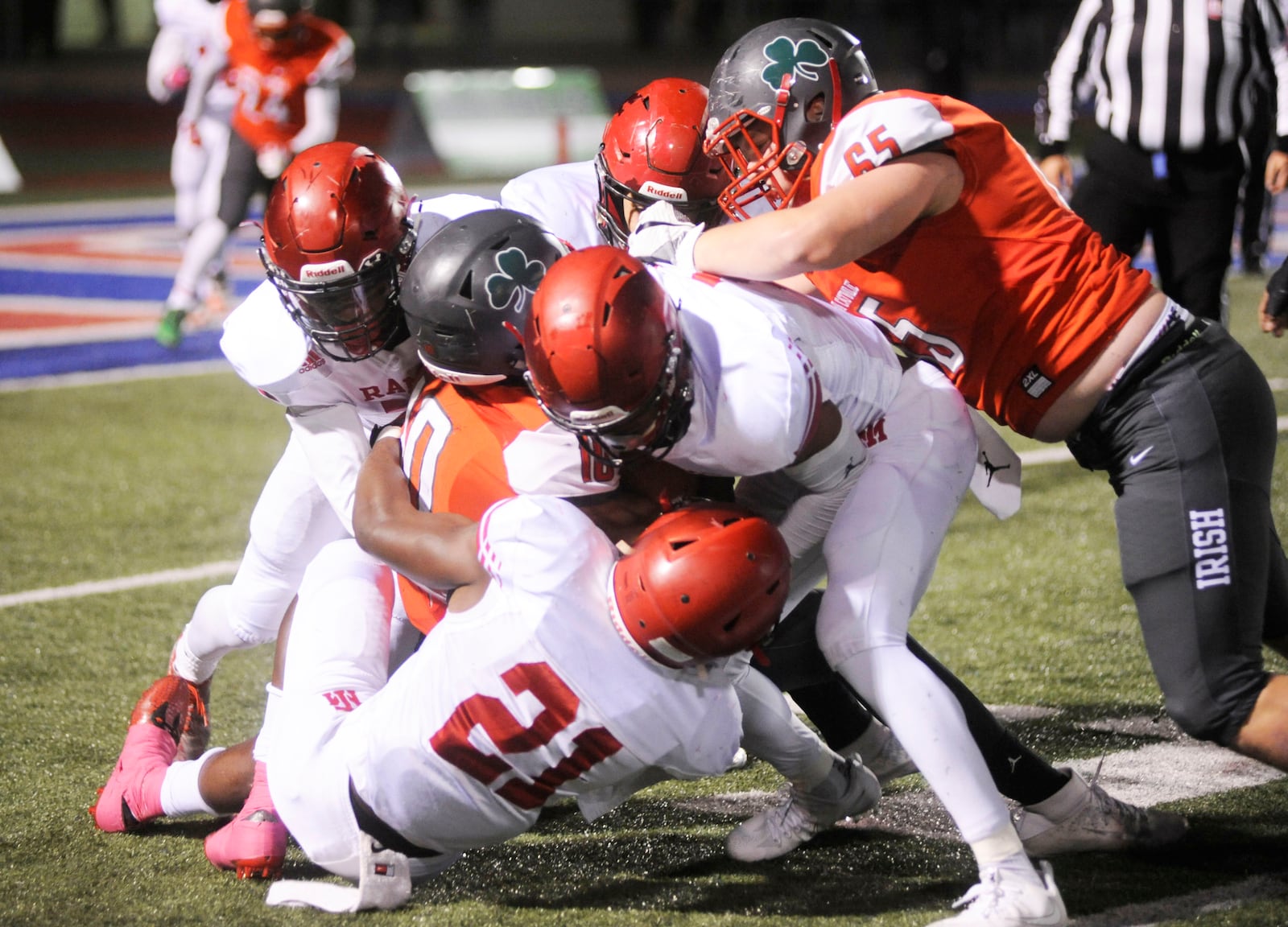 Trotwood defenders Jayvanare Nelloms (21) and teammates get defensive during a 16-7 defeat of Toledo Central Catholic in a D-III state semifinal at Piqua on Friday. MARC PENDLETON / STAFF