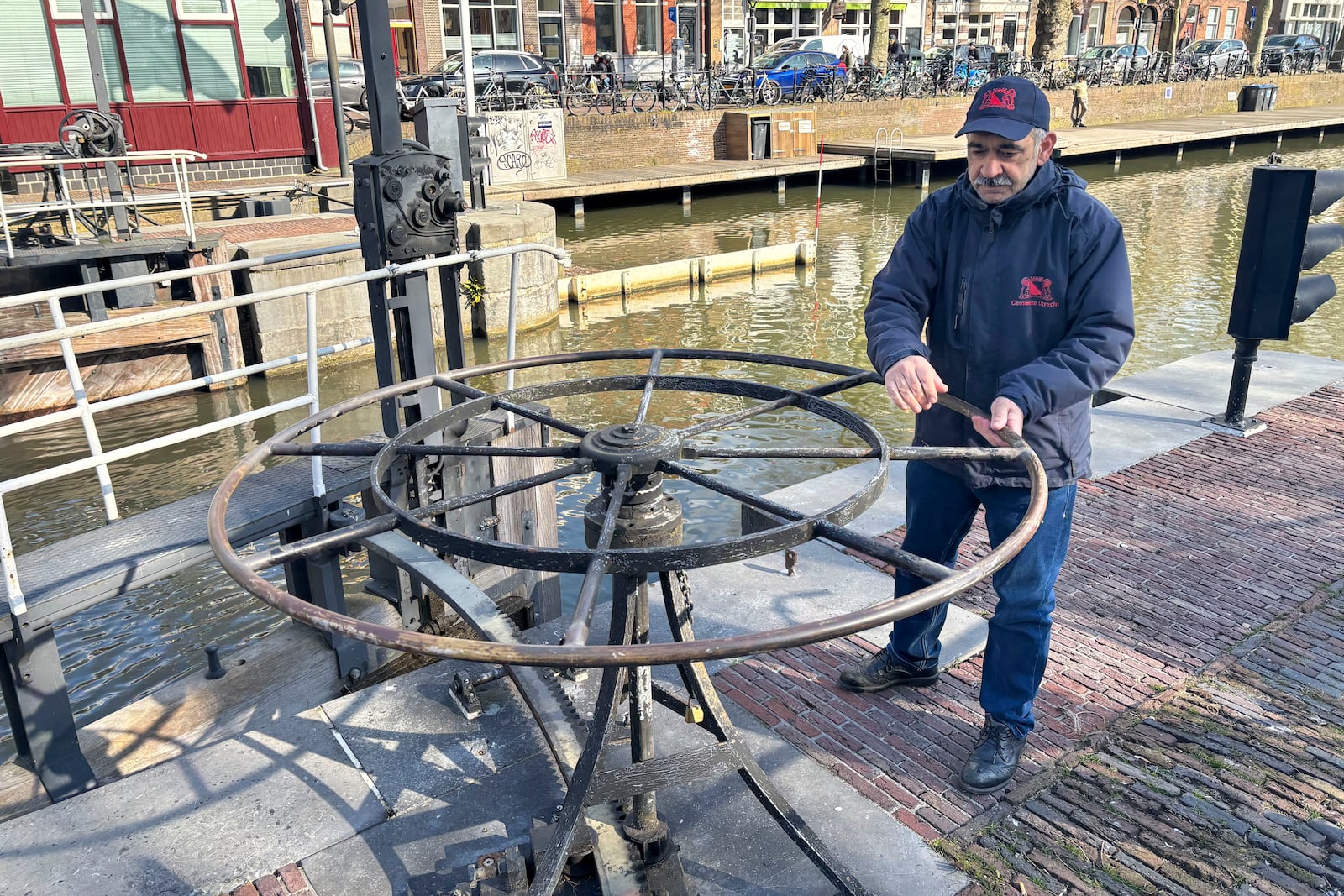 Rashid Ouchene opens the lock in Utrecht, Netherlands, Tuesday, March 11, 2025, where a "fish doorbell" was installed that lets viewers of an online livestream alert authorities to fish being held up as they make their springtime migration to shallow spawning grounds. (AP Photo/Aleksandar Furtula)