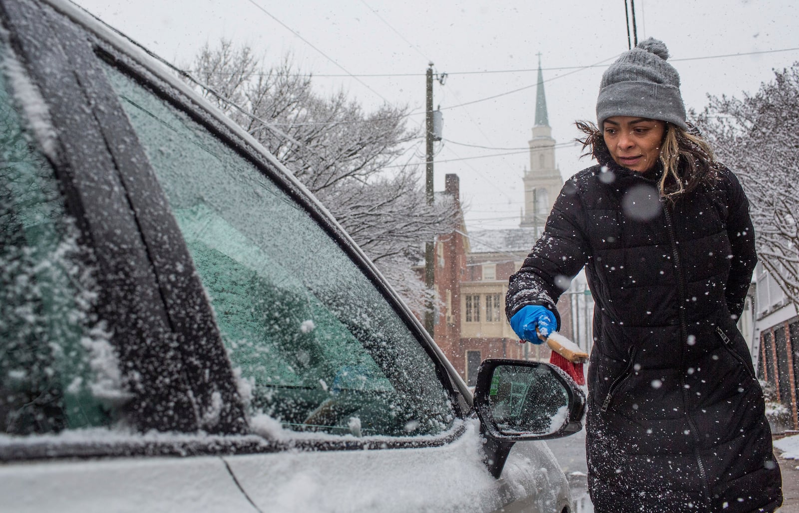 Alba Salinas clears snow off her car as a winter snowstorm hits Charlottesville, Va., Tuesday, Feb. 11, 2025. (Cal Cary/The Daily Progress via AP)