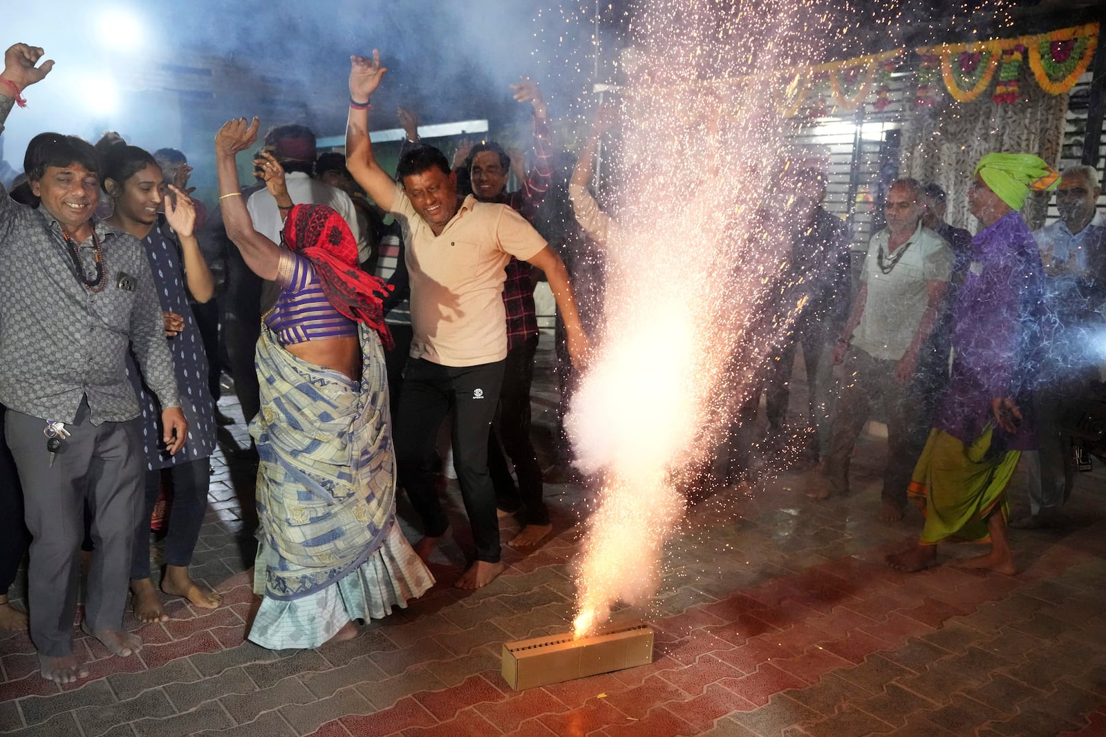 Villagers light fire crackers and dance as they celebrate the safe return of NASA astronaut Suni Williams from the International Space Station (ISS), at a temple in her ancestral village Jhulasan in Mehsana district of Gujarat state, India, Wednesday, March 19, 2025. (AP Photo/Ajit Solanki)