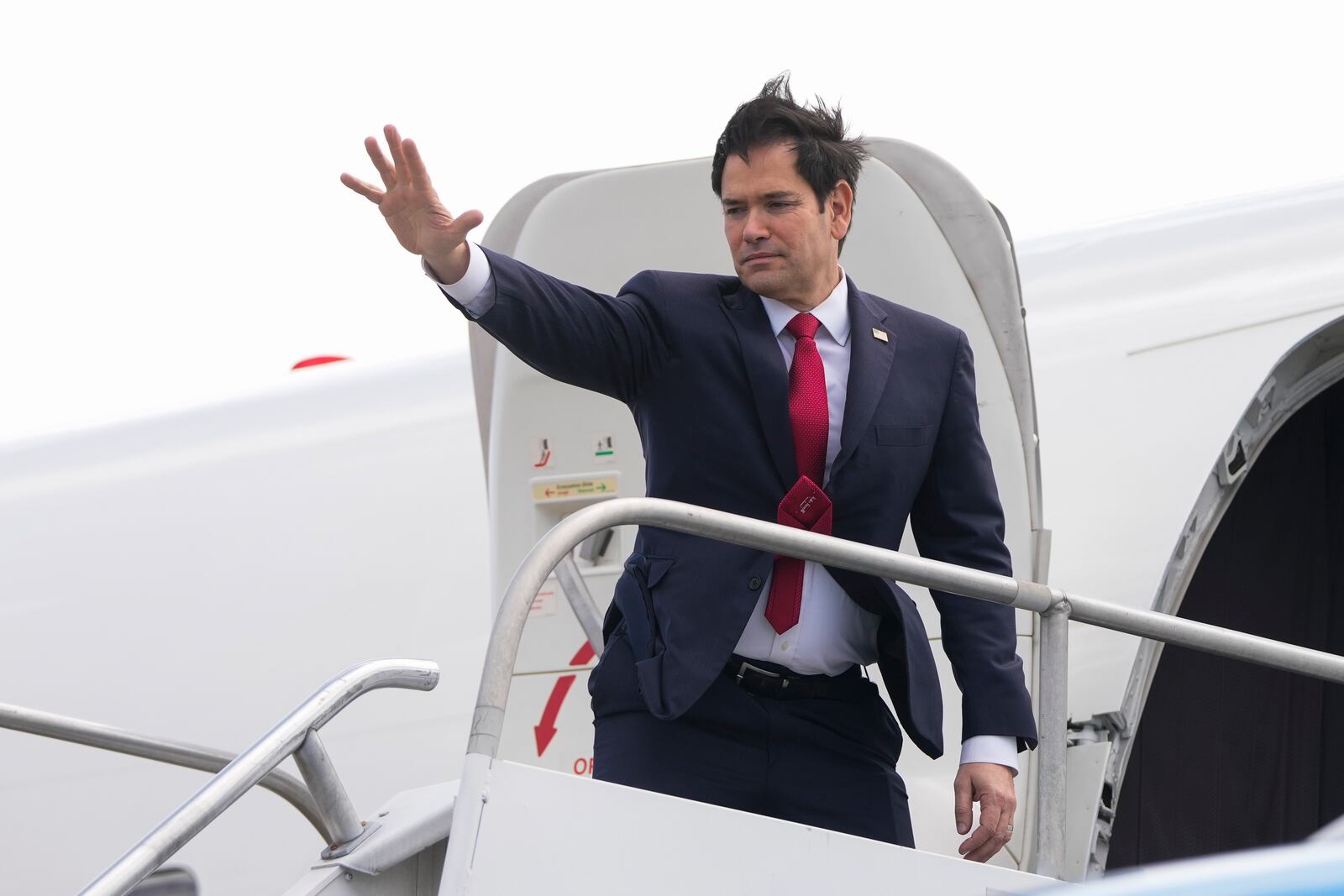 U.S. Secretary of State Marco Rubio waves goodbye as he boards a plane at Juan Santamaria International Airport near San Jose, Costa Rica, Tuesday, Feb. 4, 2025, en route to Guatemala. (AP Photo/Mark Schiefelbein, Pool)