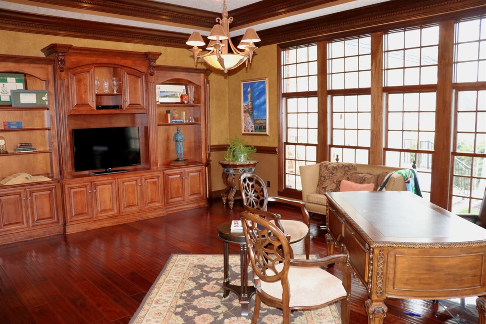 The executive study includes a media space, open bookcase, granite-counter bar and corner desk hutch. 