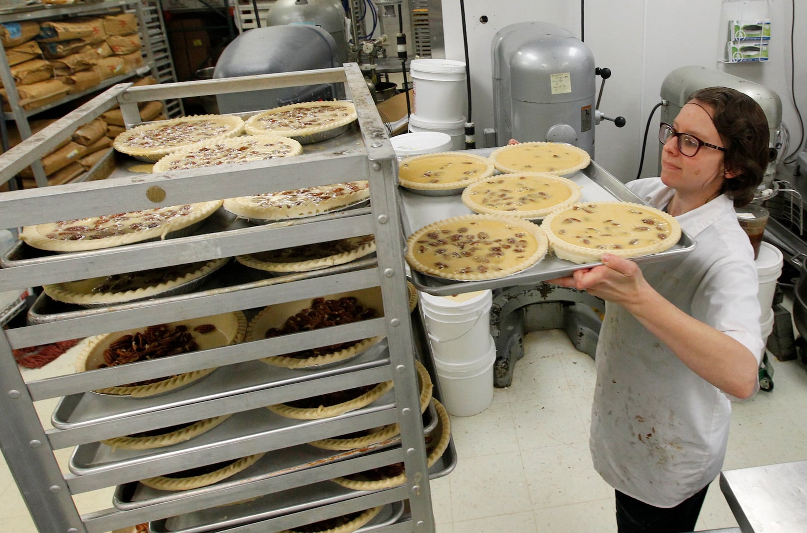 Amy Dingeldein,  manager of central bakery for Dorothy Lane Market, prepares pecan pies for baking. Dingeldein said they will make 1,000 pecan pies and 2,000 pumpkin pies in the days leading up to Thanksgiving. LISA POWELL / STAFF