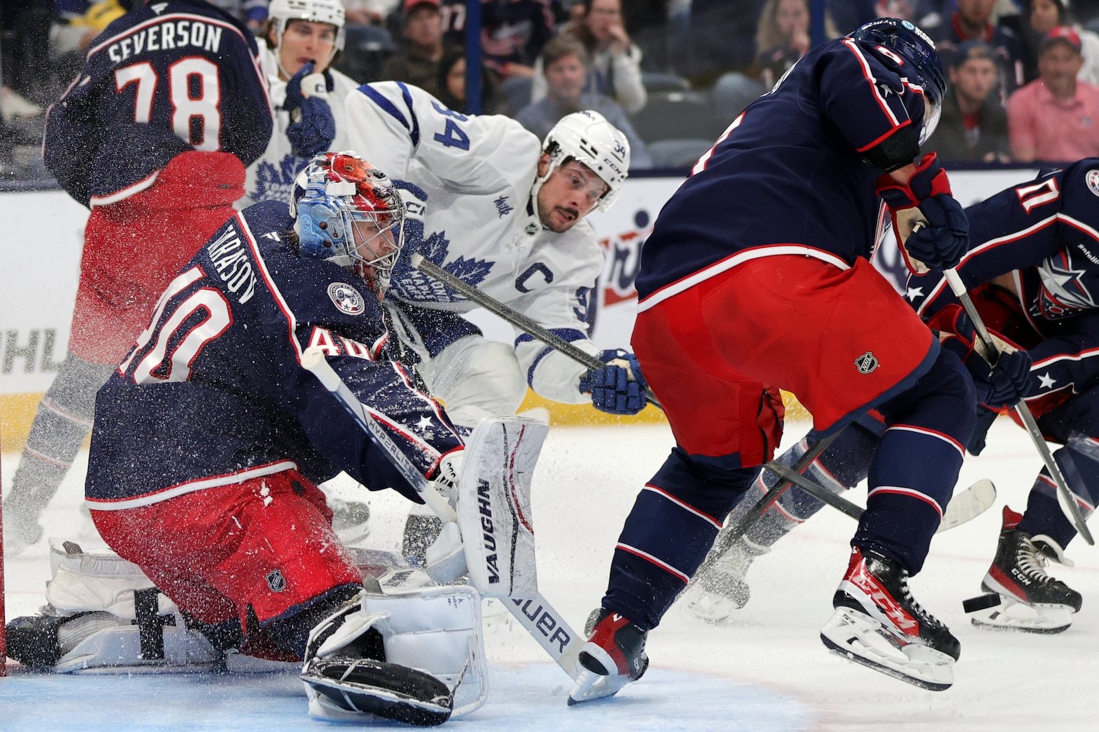 Columbus Blue Jackets goalie Daniil Tarasov, left, makes a stop behind Toronto Maple Leafs forward Auston Matthews, center, and Blue Jackets defenseman Ivan Provorov during the first period of an NHL hockey game in Columbus, Ohio, Tuesday, Oct. 22, 2024. (AP Photo/Paul Vernon)