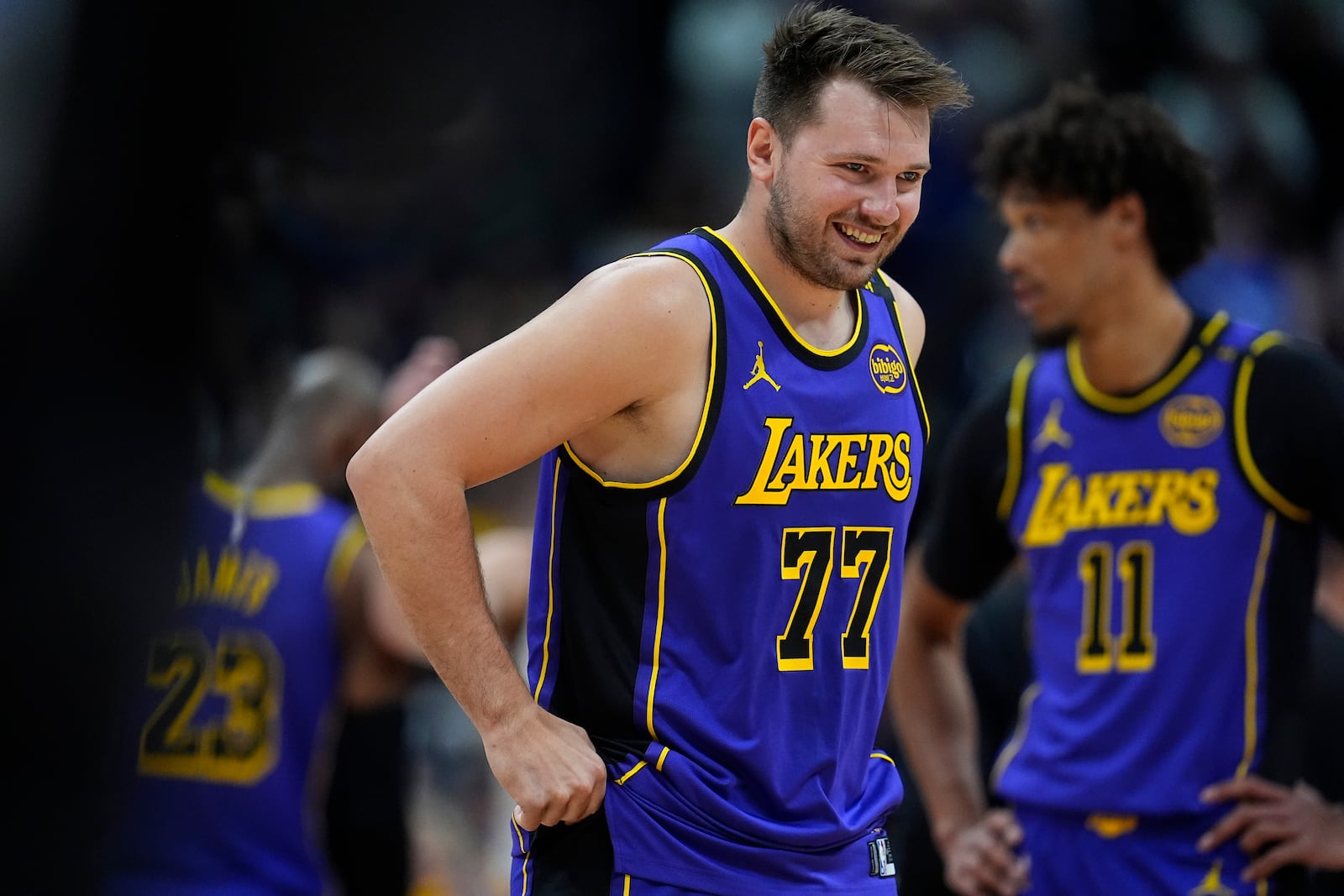 Los Angeles Lakers guard Luka Doncic laughs as he takes the court against the Denver Nuggets in the first half of an NBA basketball game Saturday, Feb. 22, 2025, in Denver. (AP Photo/David Zalubowski)