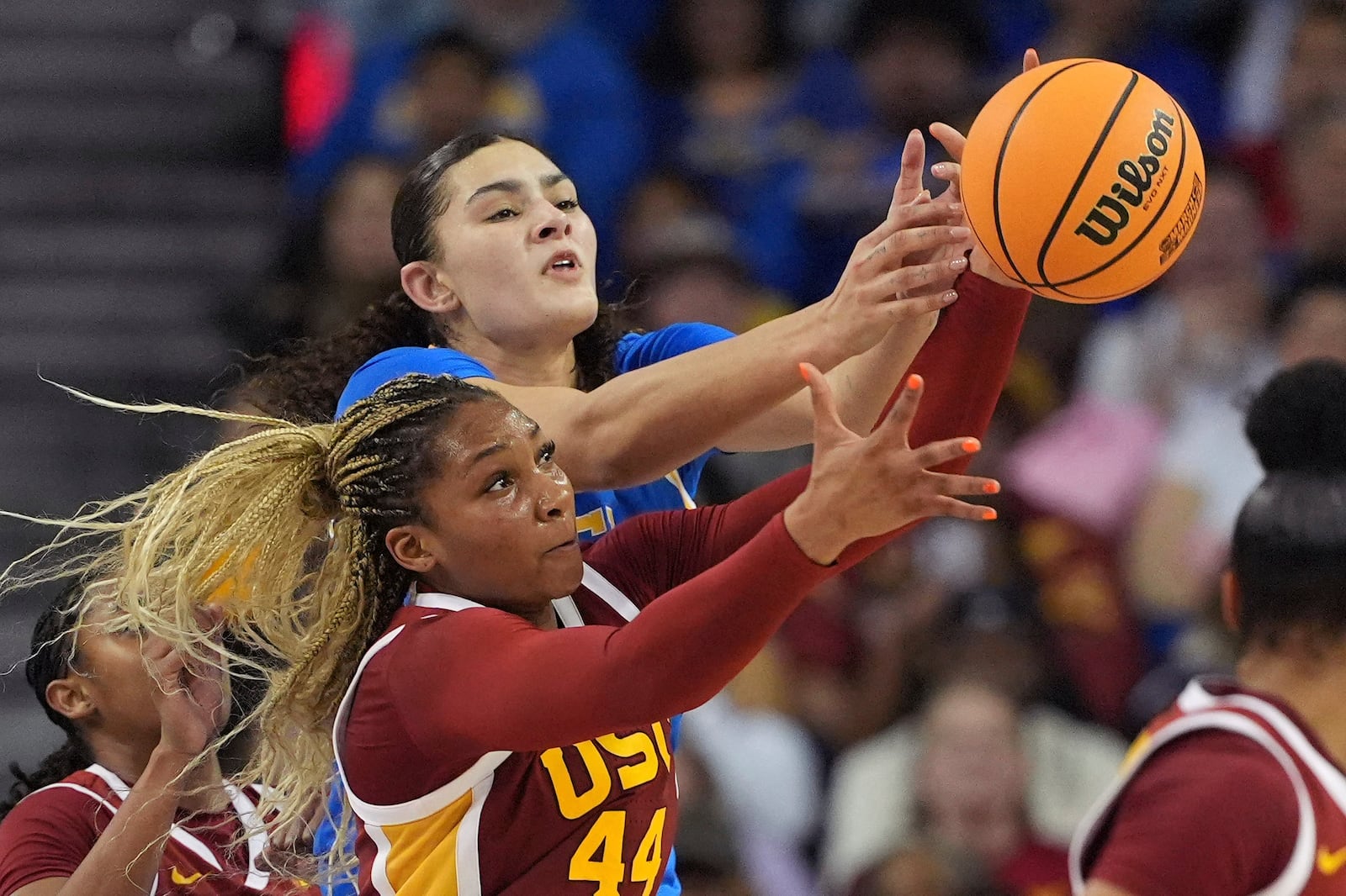 Southern California forward Kiki Iriafen, below, and UCLA center Lauren Betts reach for a loose ball during the second half of an NCAA college basketball game Saturday, March 1, 2025, in Los Angeles. (AP Photo/Mark J. Terrill)