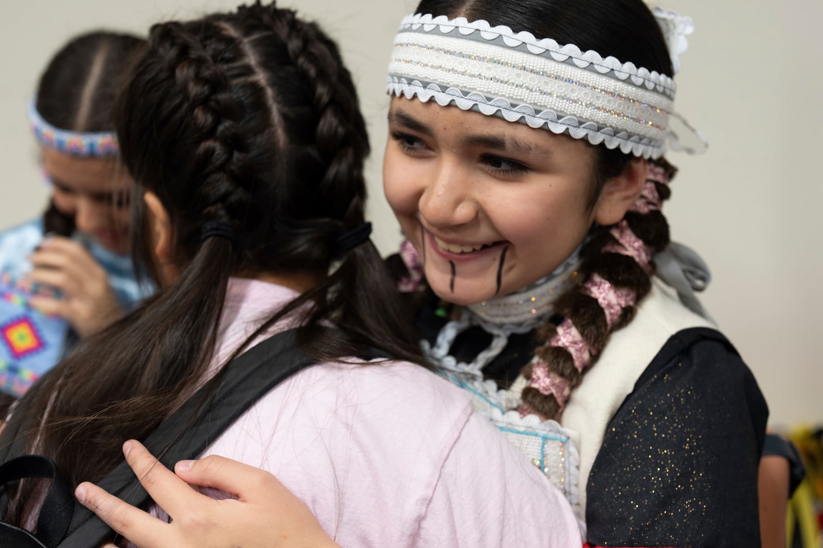 Sun-taa-chu Butler, right, hugs a friend as they get ready for a powwow at Chinook Winds Casino Resort, Saturday, Nov. 16, 2024, in Lincoln City, Ore. (AP Photo/Jenny Kane)