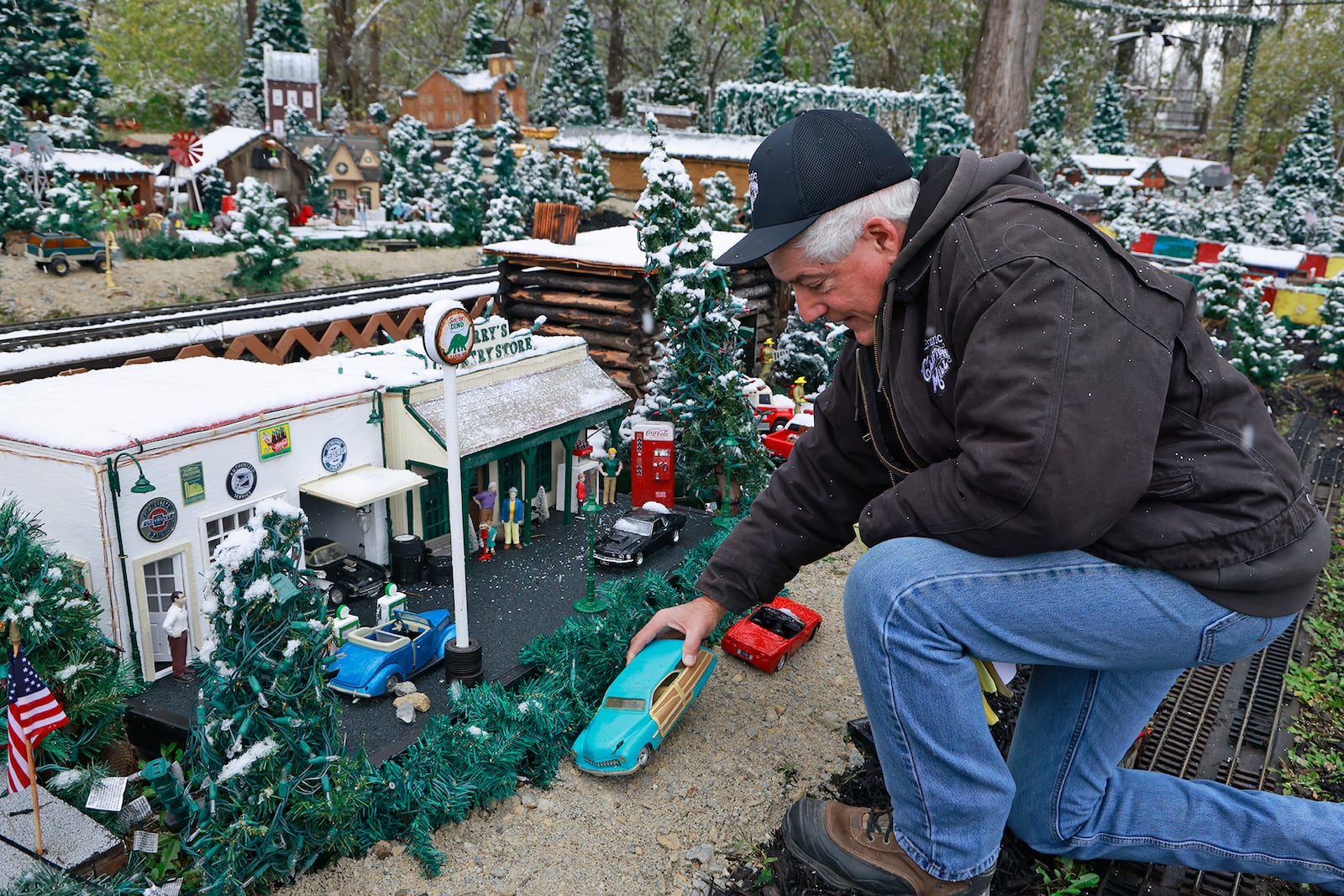 Anthony Satariano, who owns the Historic Clifton Mill with his mom, Pat, checks on the miniature village before opening night of the holiday lights. BILL LACKEY/STAFF