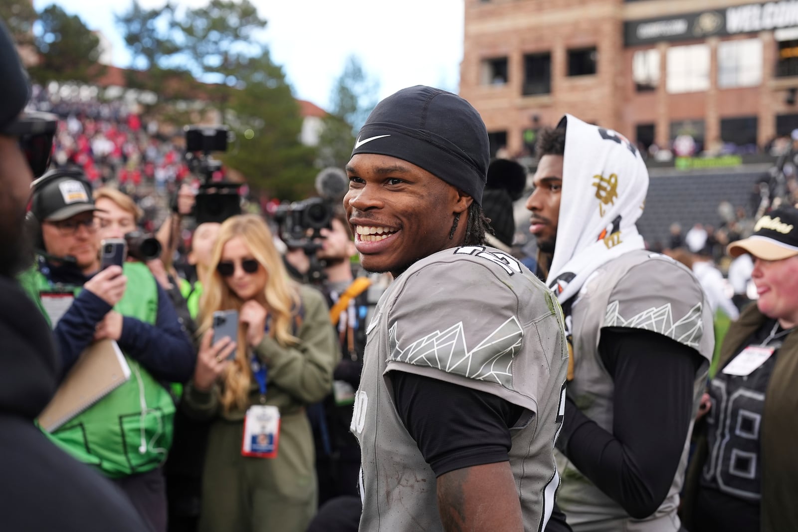 Colorado wide receiver Travis Hunter, front, jokes with teammates as he waits with quarterback Shedeur Sanders to do a television interview after an NCAA college football game against Utah Saturday, Nov. 16, 2024, in Boulder, Colo. (AP Photo/David Zalubowski)