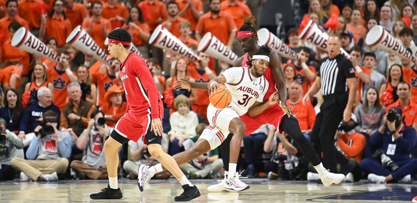 Auburn forward Chaney Johnson (31) drives past Georgia center Somtochukwu Somto Cyril (6) during the first half an NCAA college basketball game Saturday, Feb. 22, 2025, in Auburn, Ala. (AP Photo/Julie Bennett)