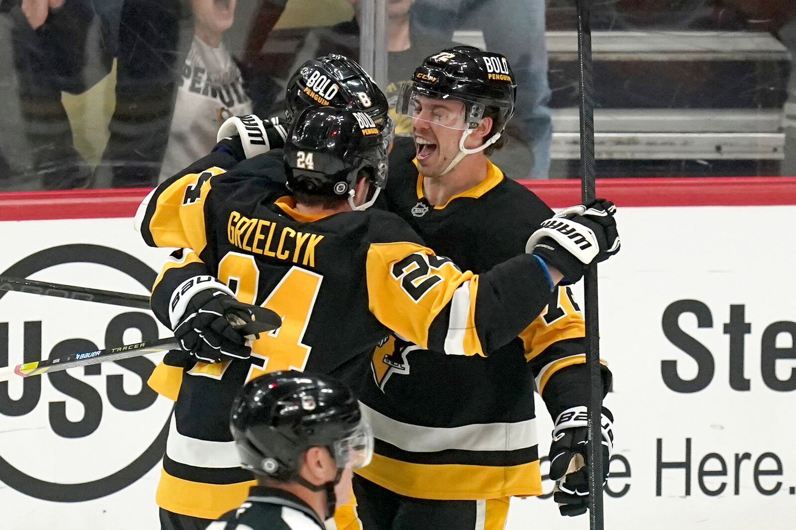 Pittsburgh Penguins' Anthony Beauvillier, right, celebrates with Matt Grzelcyk (24) and Michael Bunting (8) after scoring during the first period of an NHL hockey game against the New York Islanders, Sunday, Dec. 29, 2024, in Pittsburgh. (AP Photo/Matt Freed)