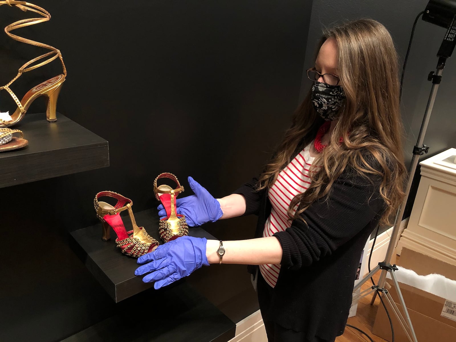 Curator Ann Glasscock installs shoes for “Walk This Way,” the current exhibit at the Taft Museum of Art. CONTRIBUTED