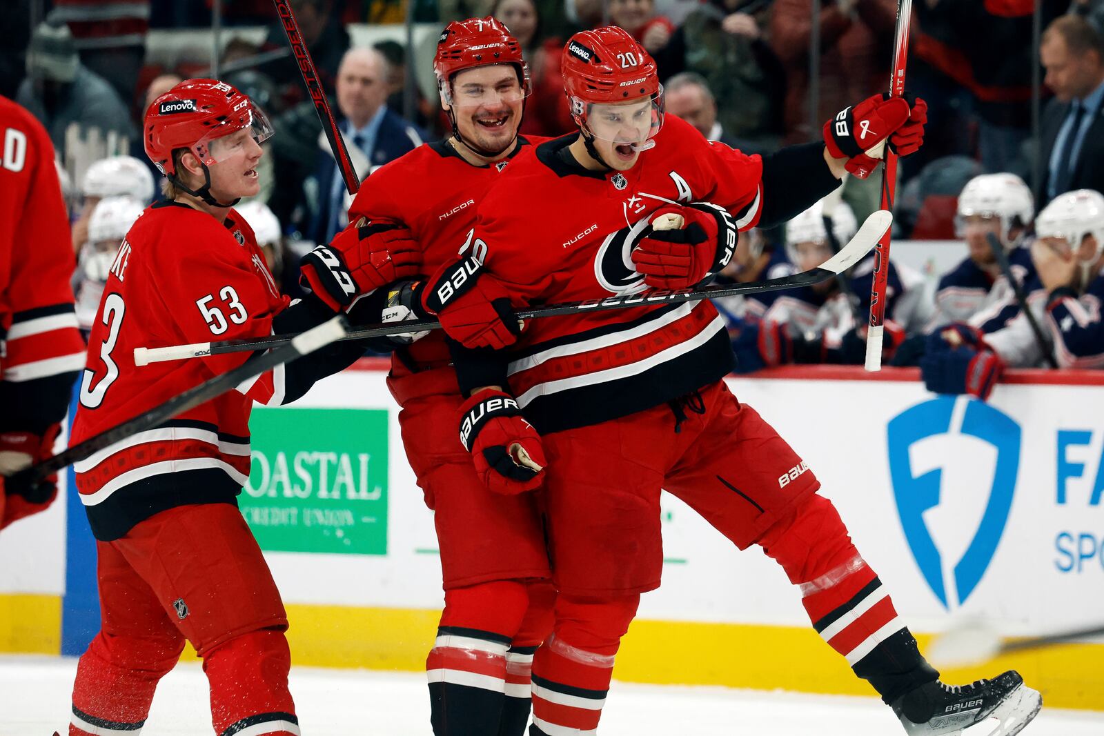 Carolina Hurricanes' Sebastian Aho (20) celebrates after his goal with teammates Dmitry Orlov, center, and Jackson Blake (53) during the second period of an NHL hockey game against the Columbus Blue Jackets in Raleigh, N.C., Thursday, Jan. 23, 2025. (AP Photo/Karl DeBlaker)