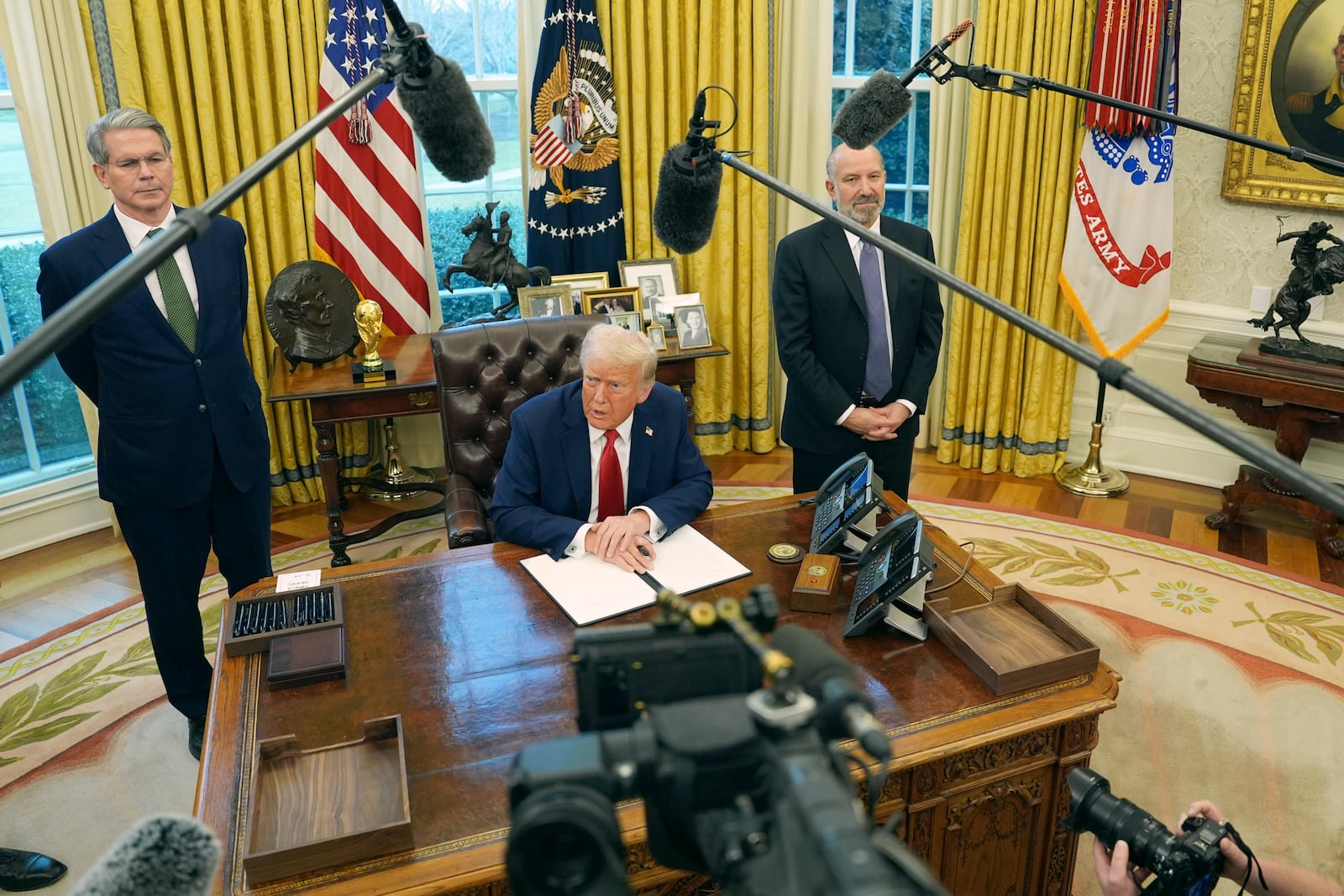 President Donald Trump speaks as Treasury Secretary Scott Bessent, left, and Commerce Secretary Howard Lutnick listen as Trump prepares to sign an executive order in the Oval Office of the White House, Monday, Feb. 3, 2025, in Washington. (AP Photo/Evan Vucci)