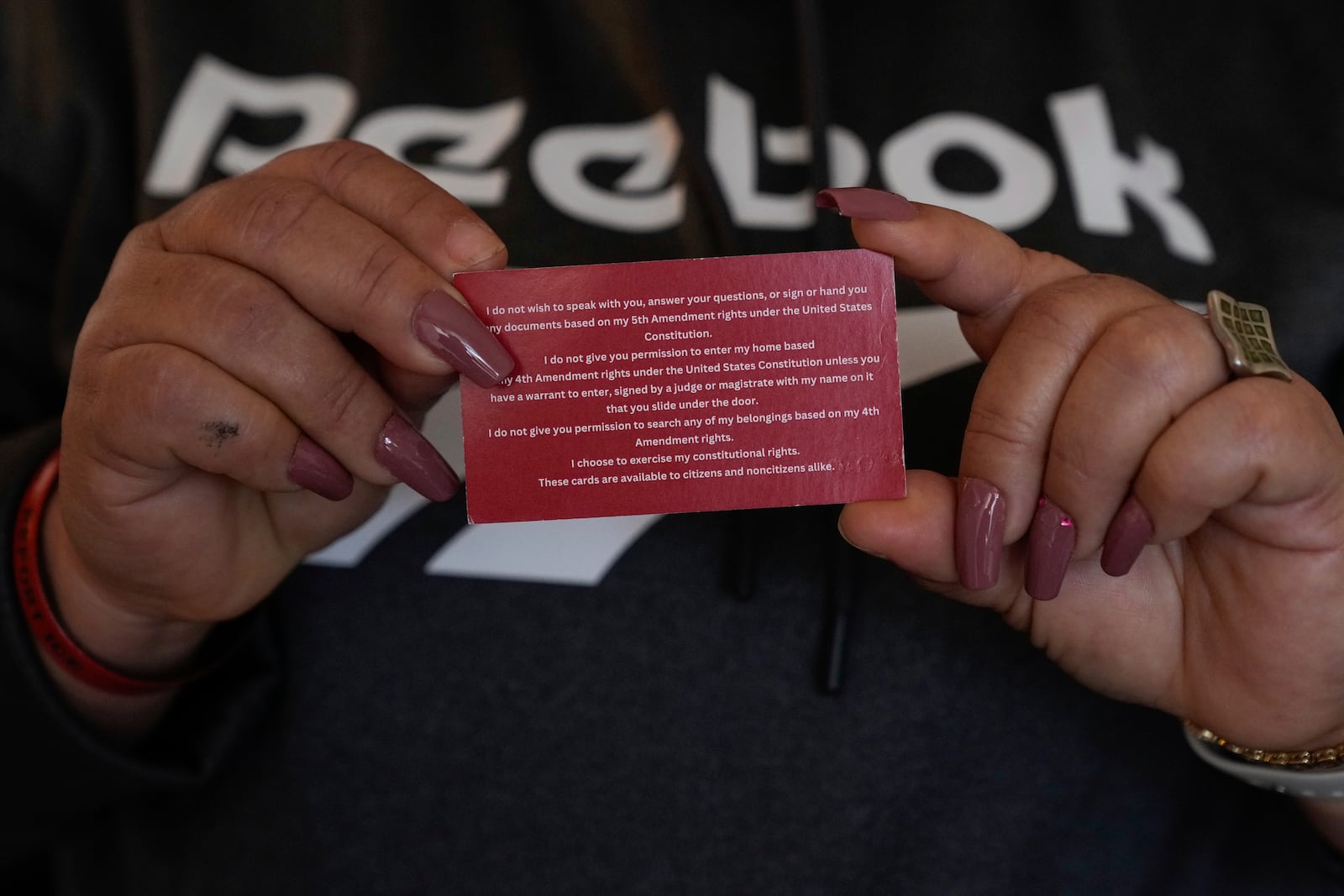 Carmen, who only shared her first name out of fear she could be targeted by immigration officials, holds a card given to her by the school her grandchildren attend Wednesday, Jan. 22, 2025, in the San Francisco Bay Area. (AP Photo/Godofredo A. Vásquez)