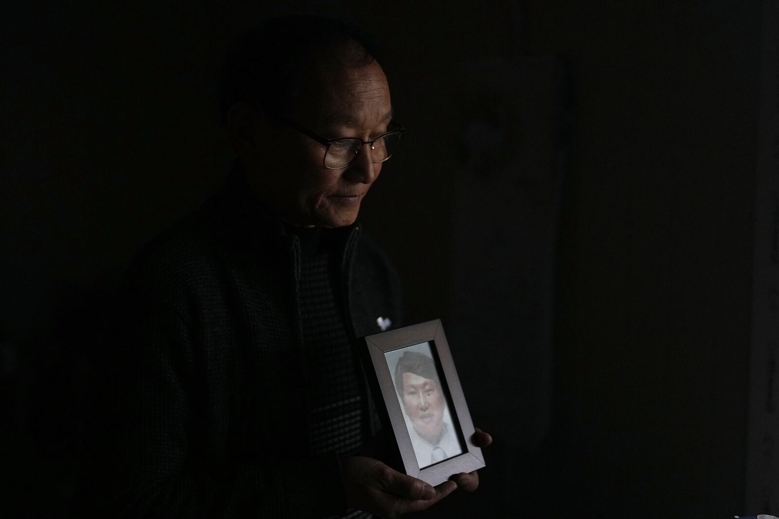 Kim Jeong-sam holds a photo of his brother of missionary Kim Jung Wook for a photo at his office in Incheon, South Korea, Nov. 29, 2024. (AP Photo/Lee Jin-man)