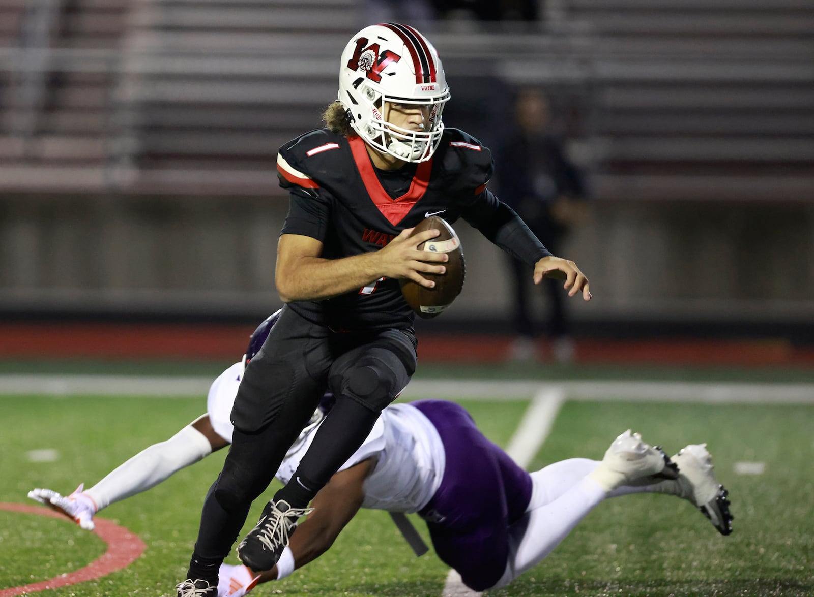 Wayne quarterback Tyrell Lewis avoids a tackle by Middletown's Jordan Vann during last week's first-round playoff game. BILL LACKEY/STAFF