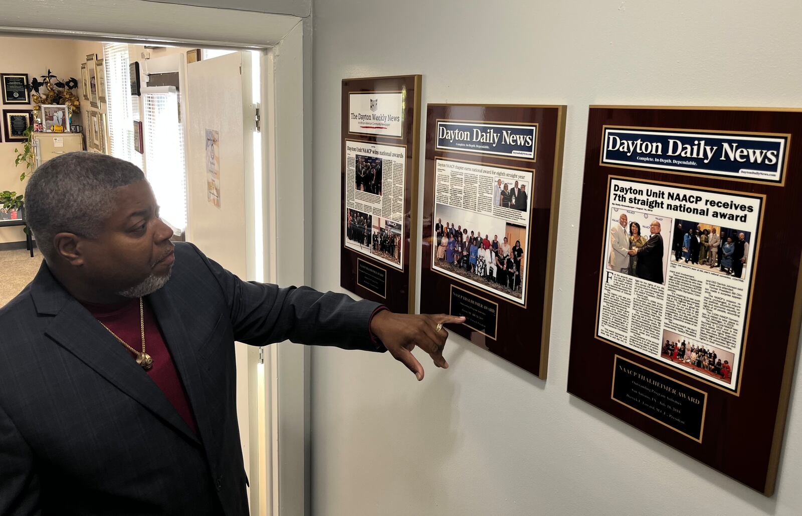 Dayton Unit NAACP President Derrick Foward shows framed news coverage from the Dayton Weekly News and Dayton Daily News, spotlighting awards the organization has won, in the NAACP's new headquarters building on Salem Avenue. JEREMY P. KELLEY / STAFF