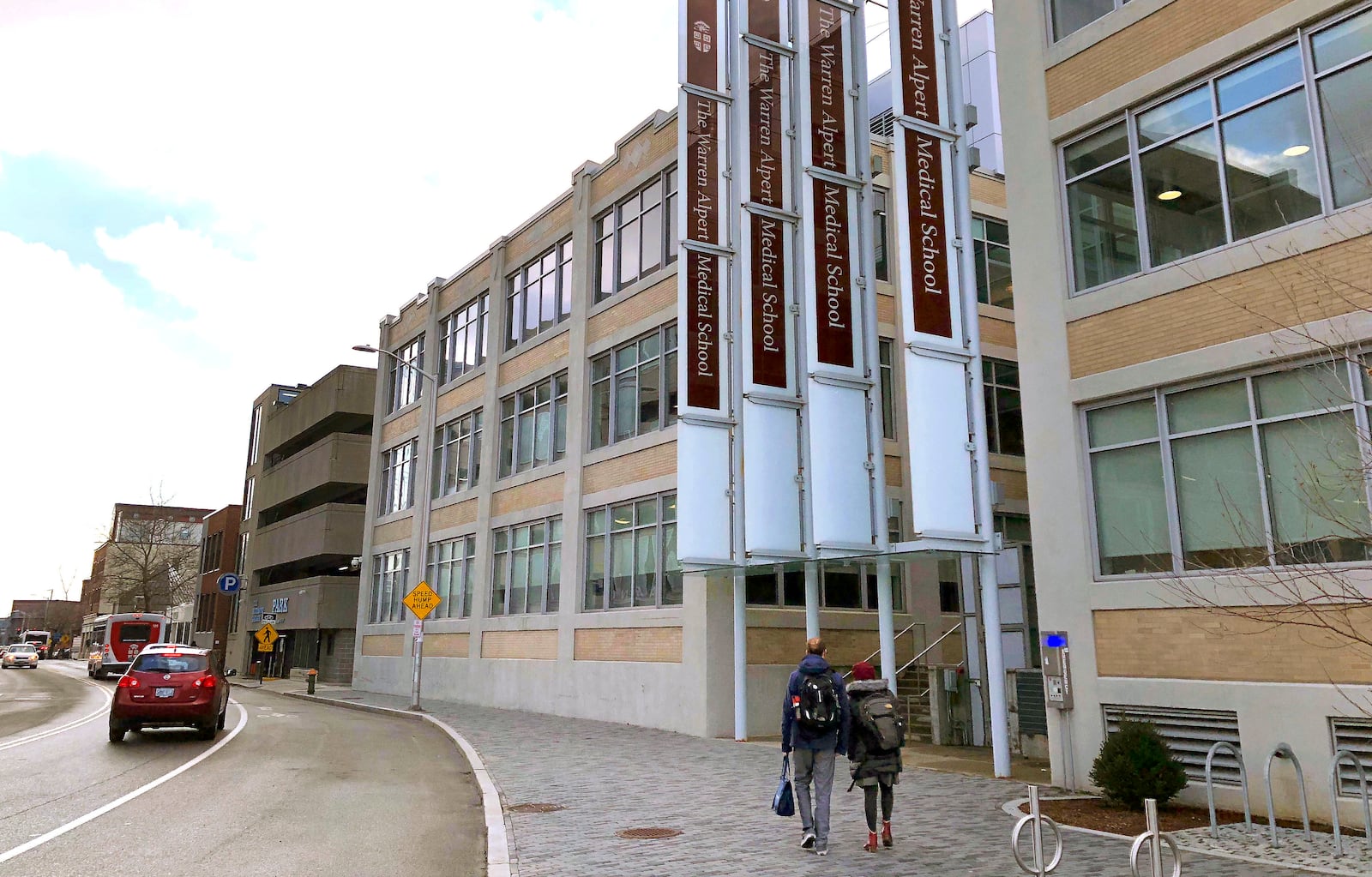 FILE - Pedestrians make their way past a building housing the Warren Alpert Medical School of Brown University, Jan. 30, 2019, in Providence, R.I. (AP Photo/Jennifer McDermott, File)