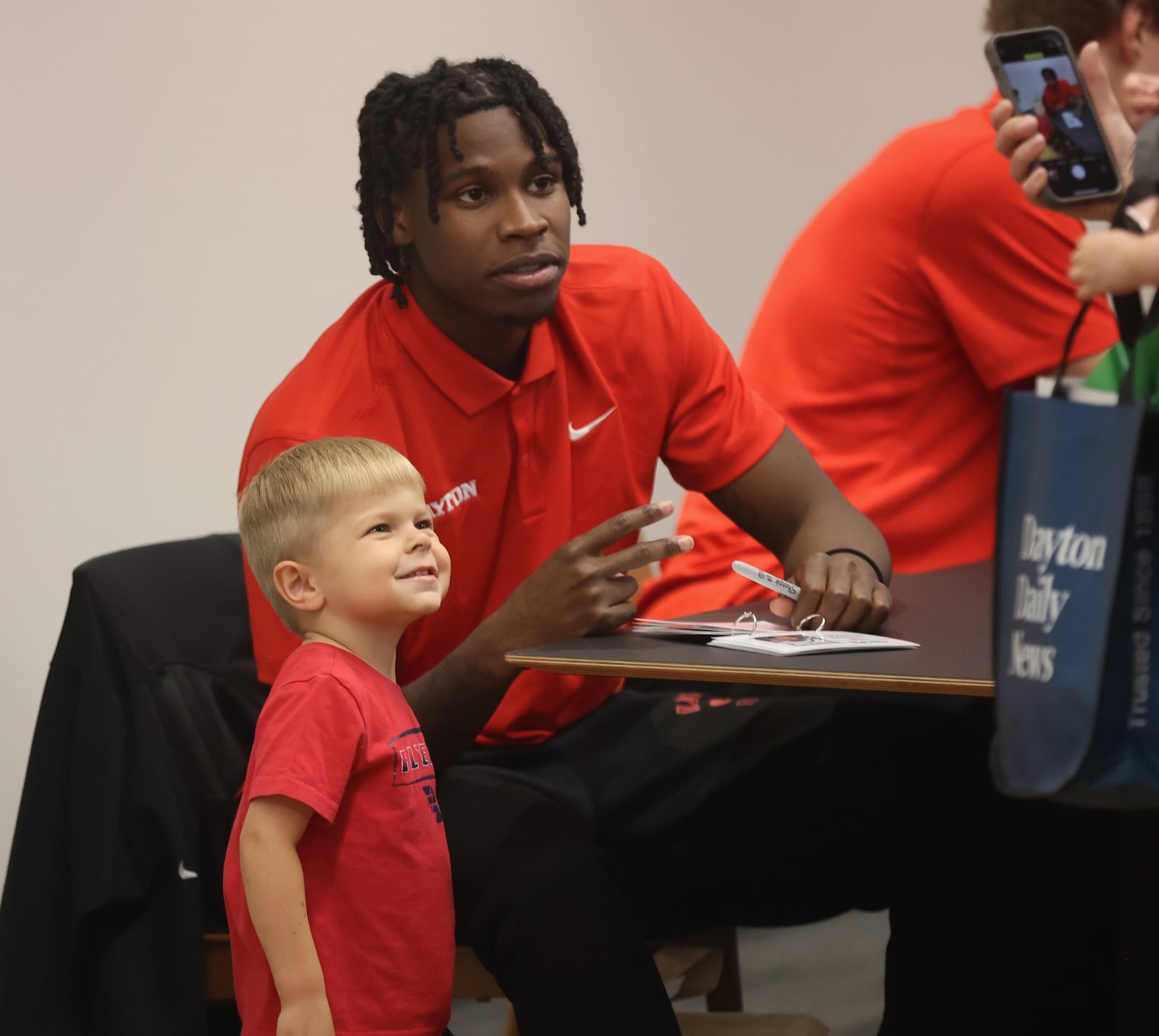 Dayton's Malachi Smith poses for a photo with a young fan, Vincent Palmer, during a meet and greet and autograph session on Wednesday, Oct. 9, 2024, at UD Arena. David Jablonski/Staff