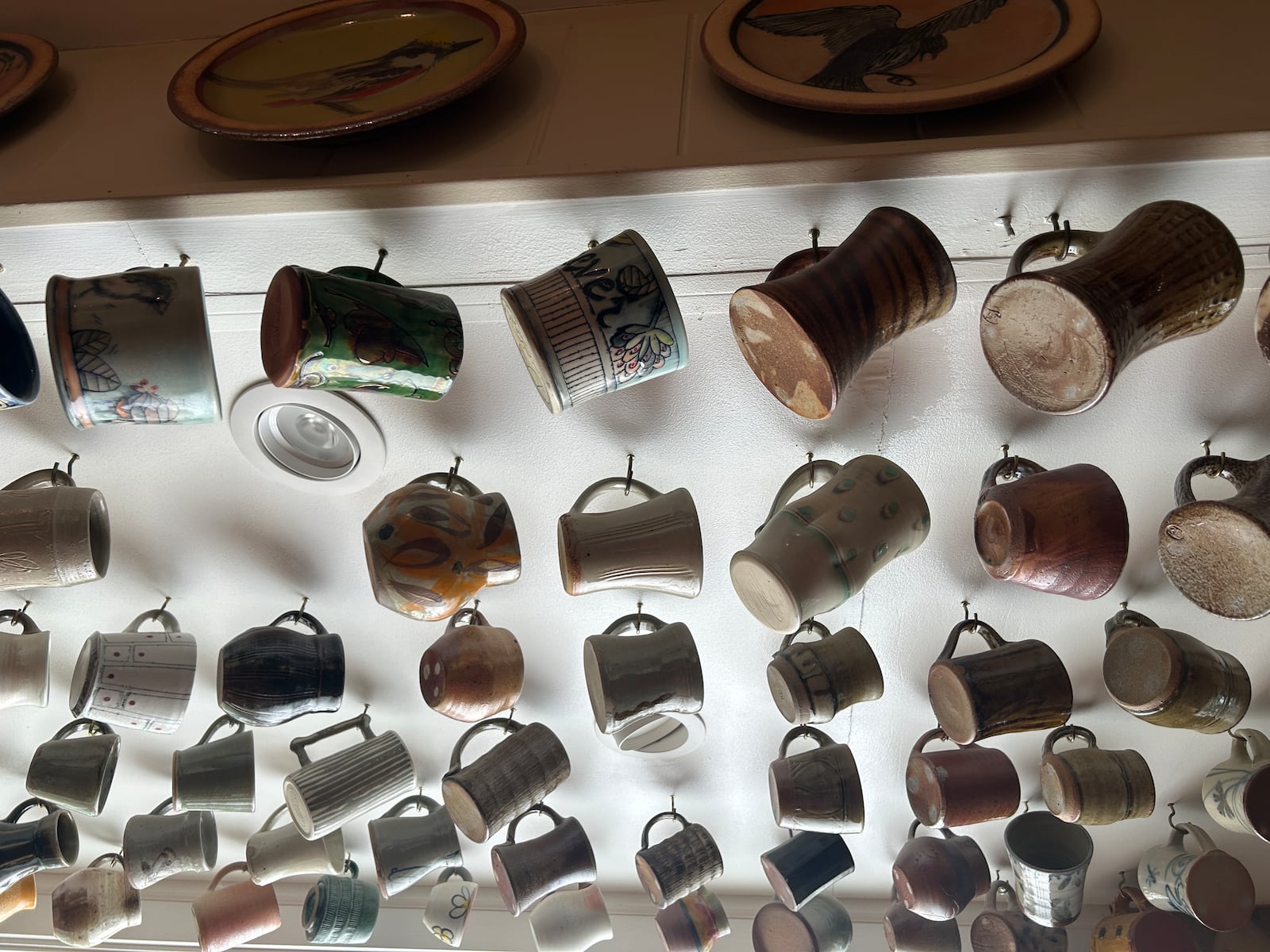 Ceramic mugs hanging from the kitchen of potter Naysan Mcllhargey, who follows in the Mingei tradition of living with functional beauty.