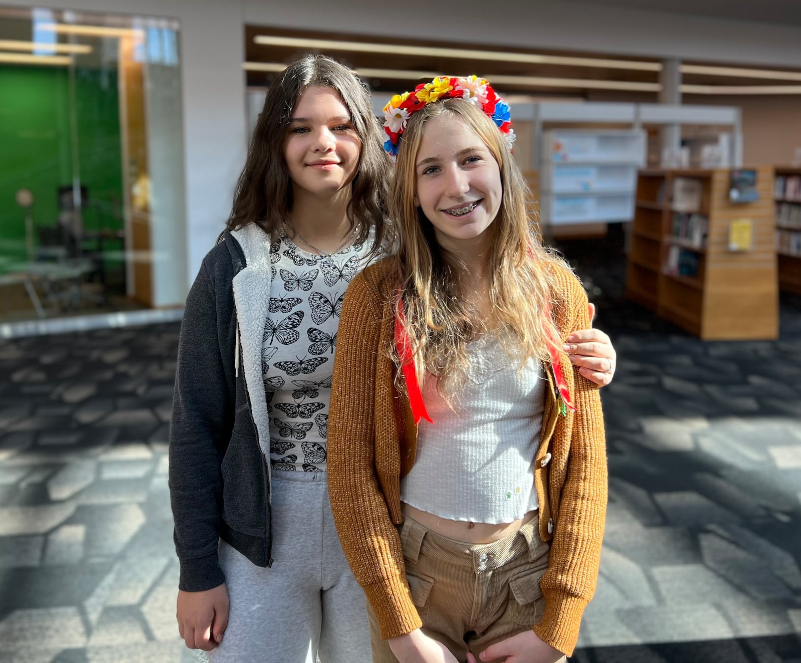 Friends Polina Fedenko and Tonya Abramiuk, both 12 and from Ukraine, attended Saturday's welcome event at the Dayton Metro Library downtown. AIMEE HANCOCK/STAFF